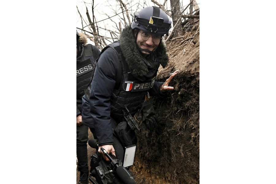 AFP journalist Arman Soldin walks in a trench as he covers the war in Ukraine, March 18, 2023. French international news agency Agence France-Presse says its Ukraine video coordinator Arman Soldin was killed Tuesday, May 9, 2023, during a rocket attack near the eastern Ukrainian city of Bakhmut. French media outlets reported that the late afternoon attack took place in the vicinity of Chasiv Yar, a town near Bakhmut. Russian forces have been trying to capture the city for nine months, making Bakhmut the focus of the war's longest battle. (Aris Messinis/AFP via AP)