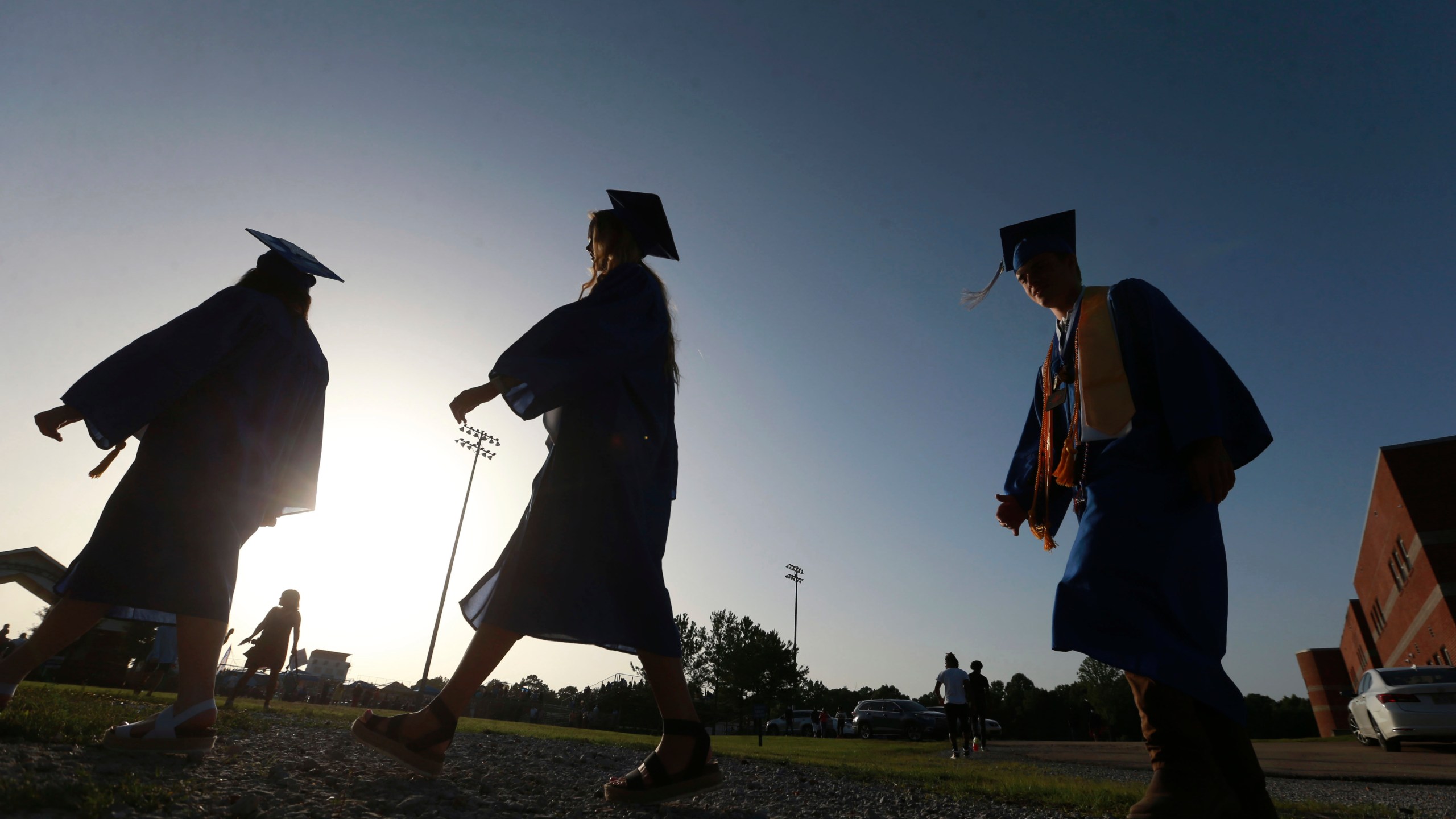 FILE - In this June 27, 2020, file photo, Saltillo High School seniors make their way to the football field as the sun begins to set for their graduation ceremony in Saltillo, Miss. Federal parent PLUS loans have become a last resort for many lower-income families paying for a kid’s college education. Today, parent PLUS loan debt totals $108.5 billion among 3.7 million borrowers, and the average borrower owes more than $29,000. (Thomas Wells/The Northeast Mississippi Daily Journal via AP, File)