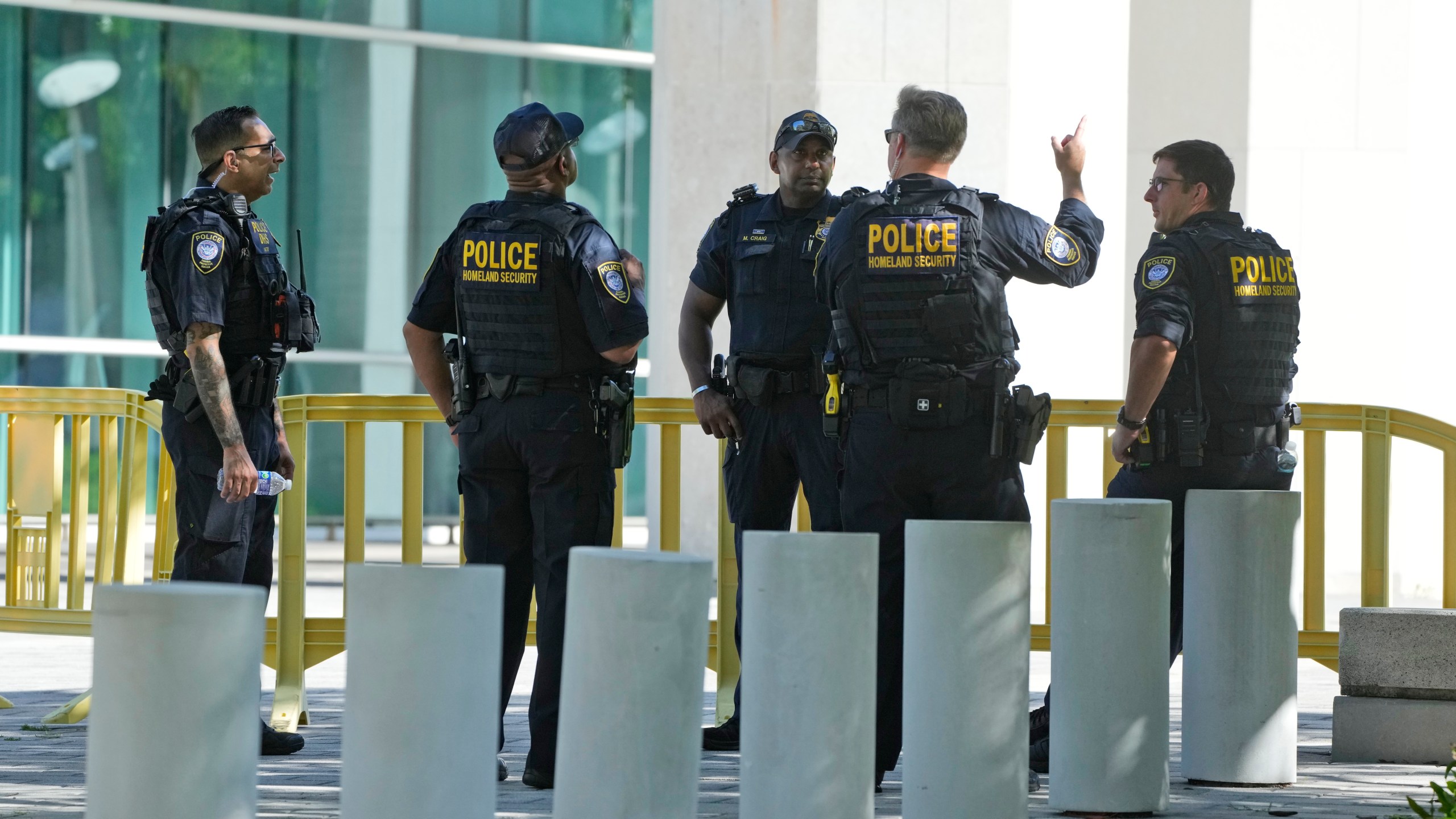 Federal Protective Service Police talk outside the Wilkie D. Ferguson Jr. U.S. Courthouse, Monday, June 12, 2023, in Miami. Former President Donald Trump is set to appear at the federal court Tuesday, on dozens of felony charges accusing him of illegally hoarding classified information. (AP Photo/Wilfredo Lee)