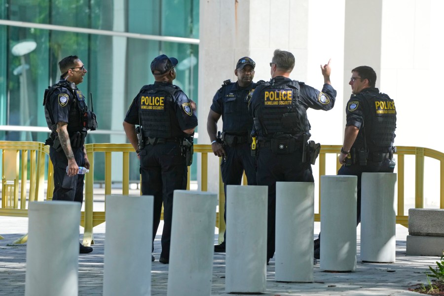 Federal Protective Service Police talk outside the Wilkie D. Ferguson Jr. U.S. Courthouse, Monday, June 12, 2023, in Miami. Former President Donald Trump is set to appear at the federal court Tuesday, on dozens of felony charges accusing him of illegally hoarding classified information. (AP Photo/Wilfredo Lee)