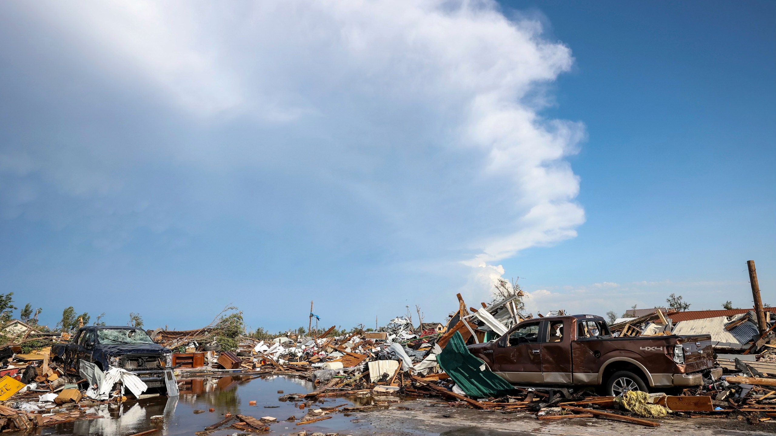 Damaged pickup trucks sit among debris after a tornado passed through a residential area in Perryton, Texas, Thursday, June 15, 2023. (AP Photo/David Erickson)