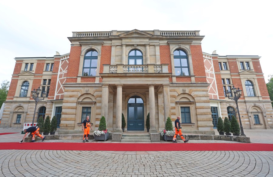 The red carpet is fixed in front of the Festspielhaus for the opening of the Bayreuth Richard Wagner Festival in Bayreuth, Germany, Tuesday July 25, 2023. (Karl-Josef Hildenbrand/dpa via AP)