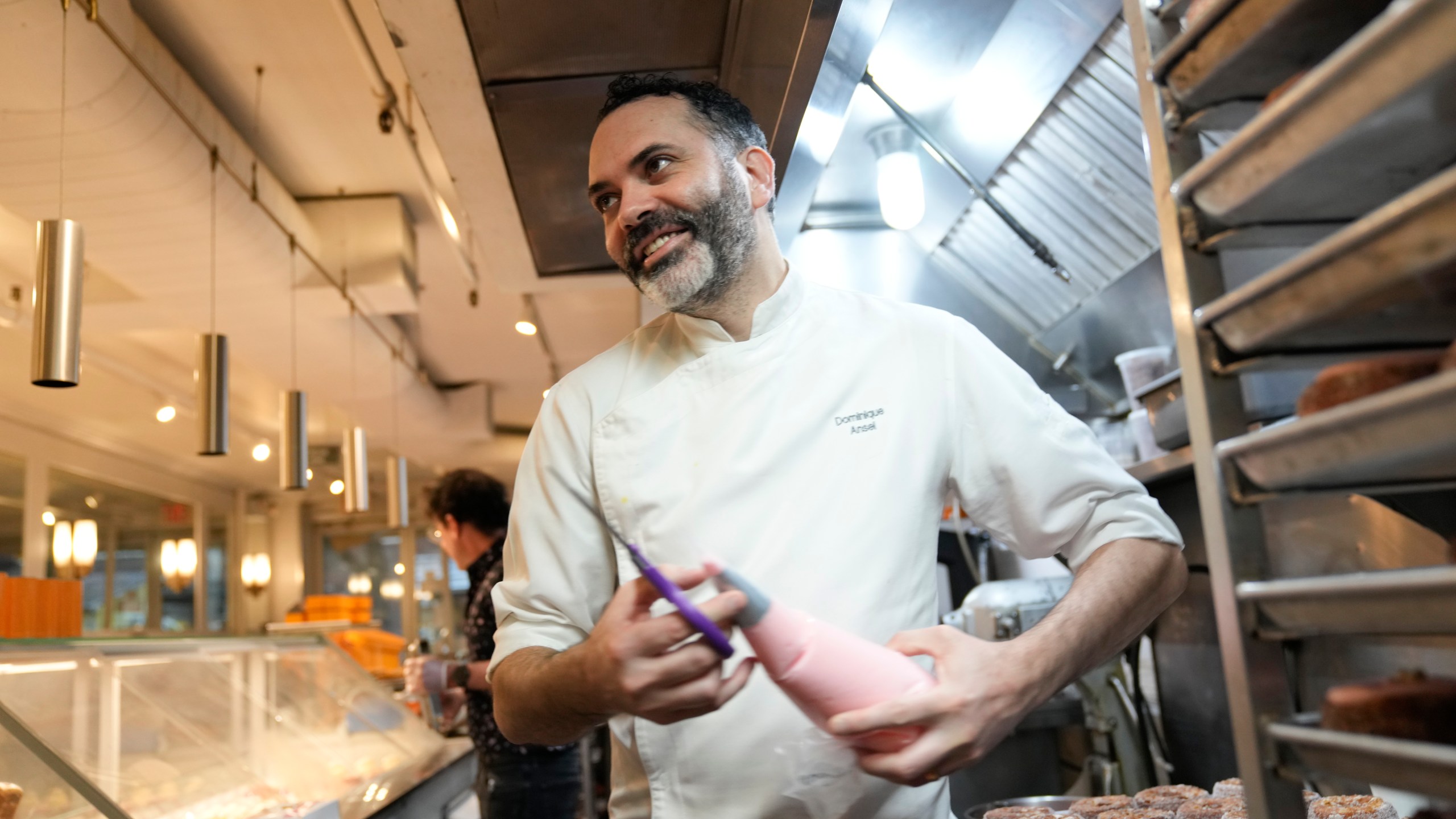 Dominique Ansel helps to prepare for opening at his namesake bakery in New York, Thursday, Sept. 28, 2023. In 2013, before most people knew the term “going viral,” the French pastry chef created the Cronut, a cross between a croissant and a doughnut, at his newly opened New York bakery. (AP Photo/Seth Wenig)