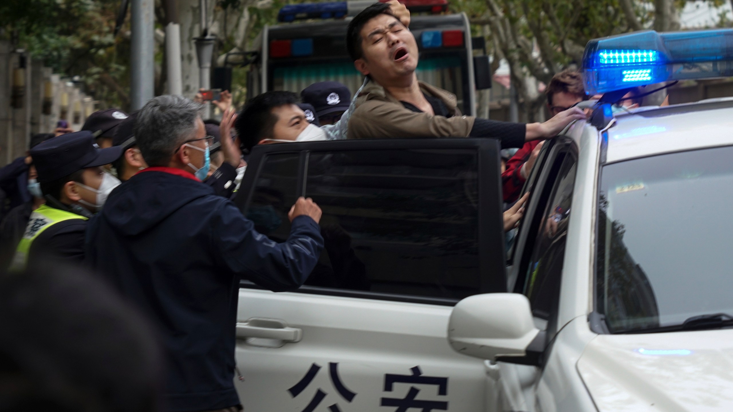 FILE - A protester resist as he is taken away by policemen from a street in Shanghai, China on Nov. 27, 2022. Thousands of people demonstrated across China in what came to be called the White Paper movement, after the blank sheets of paper protesters used to represent the country's strict censorship controls. One year later, China has all but forgotten the protests. The state reacted quickly, breaking up the marches with arrests and threats and ending COVID-19 controls. (AP Photo, File)