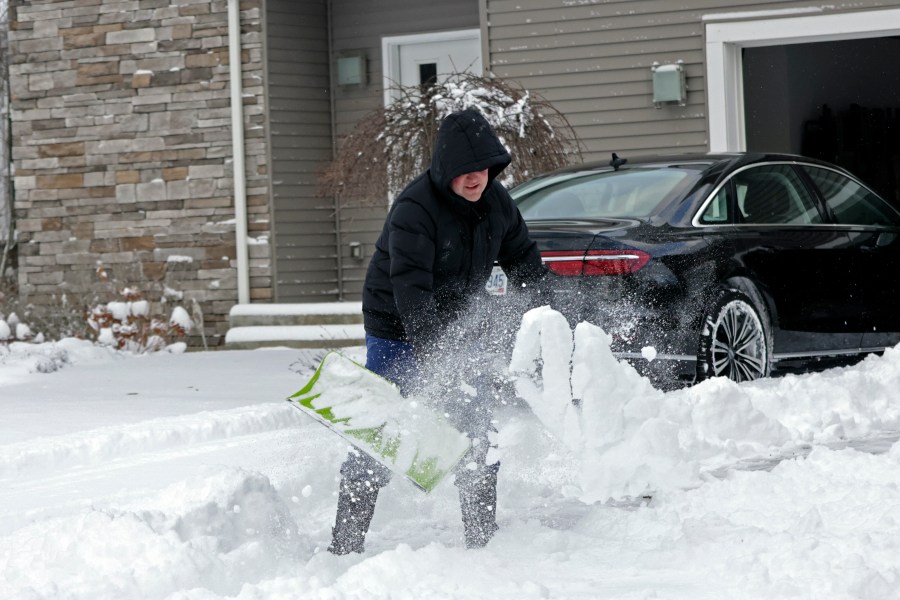 A man clears his driveway in Beachwood, Ohio, after heavy lake-effect snowfall arrived overnight, Tuesday, Nov. 28, 2023. A winter storm shut down schools in Cleveland and other areas Tuesday and the blanket of snow made driving on heavily traveled Interstate 90 in northern Ohio treacherous. (David Petkiewicz/Cleveland.com via AP)