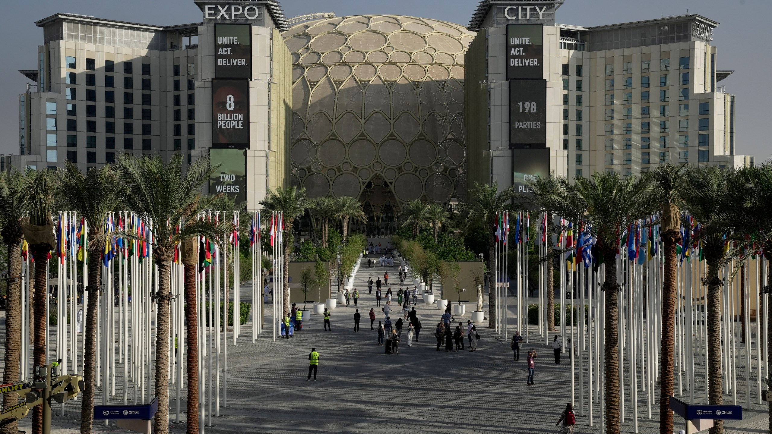 FILE - People walk through the venue for the COP28 U.N. Climate Summit with the Al Wasl Dome in the background at Expo City, Nov. 29, 2023, in Dubai, United Arab Emirates. (AP Photo/Joshua A. Bickel, File)