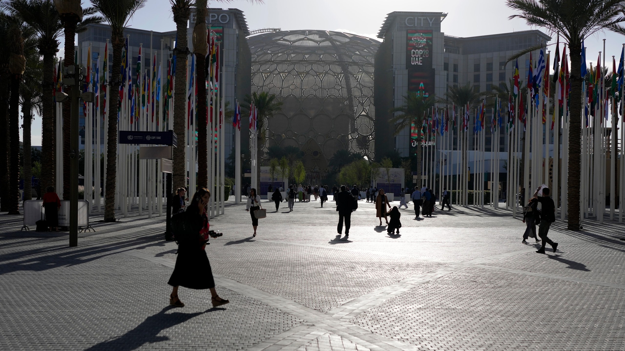 FILE - People walk through the venue at the COP28 U.N. Climate Summit near the Al Wasl Dome at Expo City, Thursday, Nov. 30, 2023, in Dubai, United Arab Emirates. (AP Photo/Rafiq Maqbool, File)