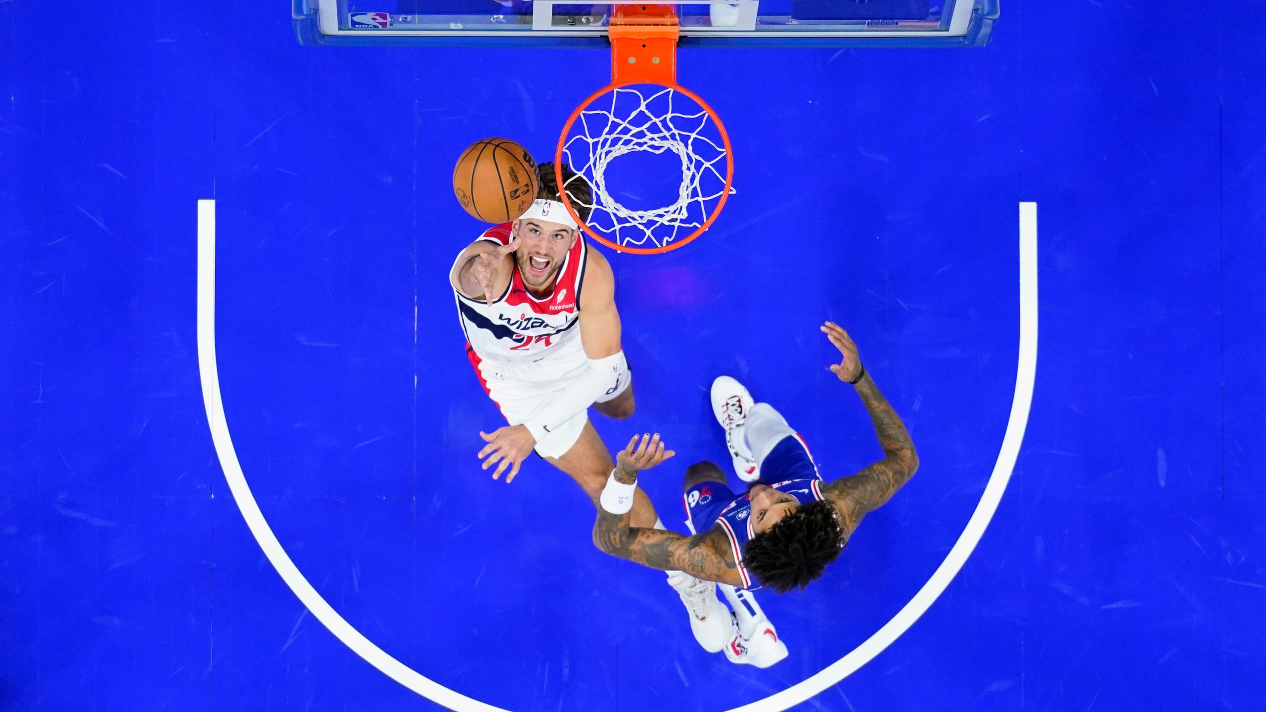 Washington Wizards' Corey Kispert, left, goes up for a shot past Philadelphia 76ers' Kelly Oubre Jr. during the first half of an NBA basketball game, Monday, Nov. 6, 2023, in Philadelphia. (AP Photo/Matt Slocum)