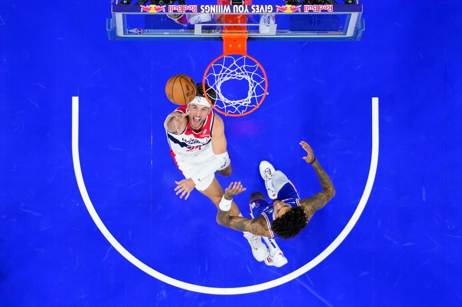 Washington Wizards' Corey Kispert, left, goes up for a shot past Philadelphia 76ers' Kelly Oubre Jr. during the first half of an NBA basketball game, Monday, Nov. 6, 2023, in Philadelphia. (AP Photo/Matt Slocum)