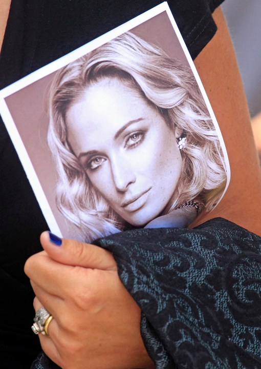 FILE - A mourner carries a program at the funeral for Reeva Steenkamp, in Port Elizabeth, South Africa on Feb. 19, 2013. Oscar Pistorius is due on Friday, Jan. 5, 2024 to be released from prison on parole to live under strict conditions at a family home after serving nearly nine years of his murder sentence for the shooting death of girlfriend Reeva Steenkamp on Valentine’s Day 2013. (AP Photo/Schalk van Zuydam, File)