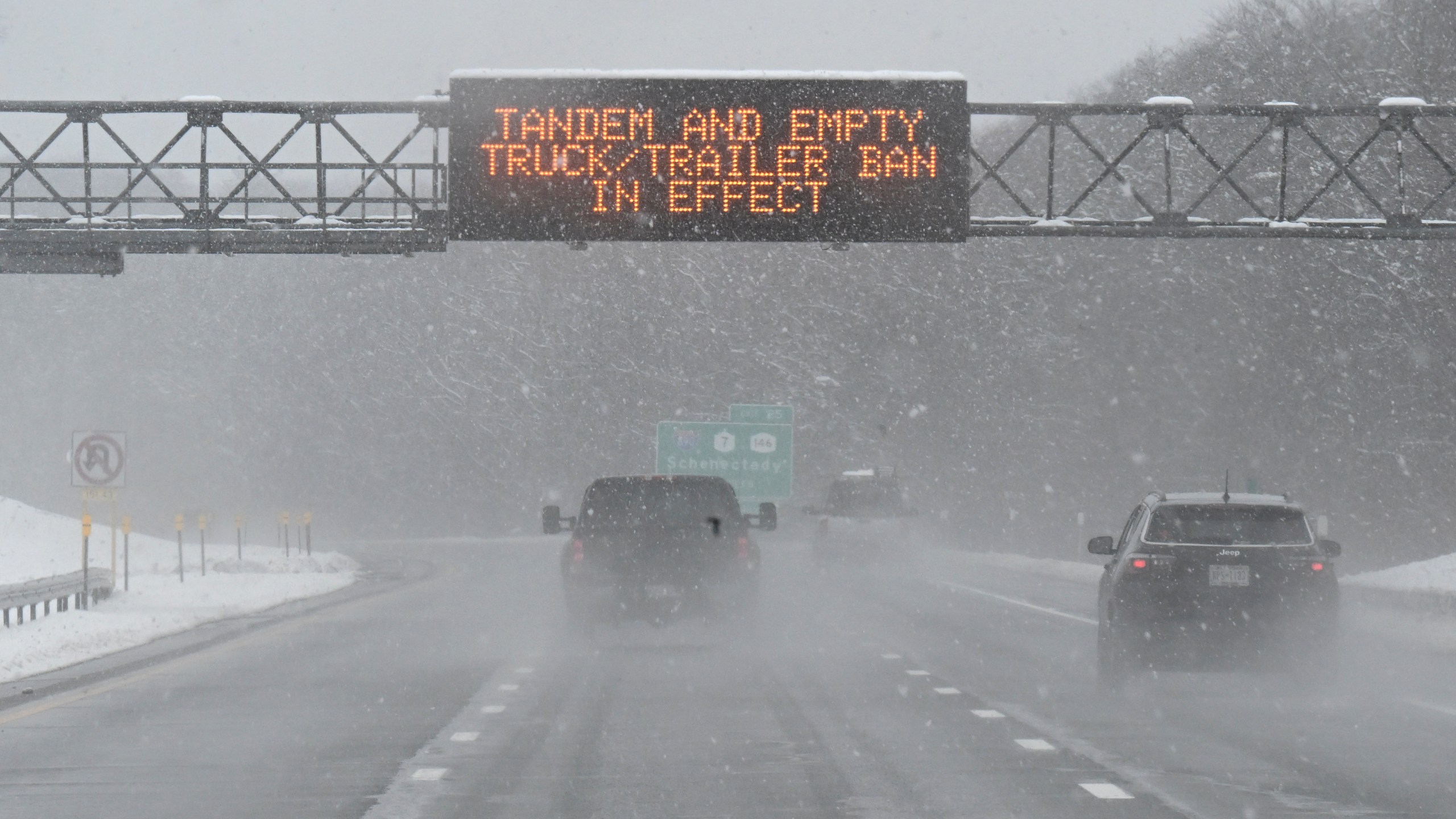 FILE - A roadway caution sign is seen on the New York Thruway as motorists commute during a winter snow storm, March 14, 2023, in Albany, N.Y. A winter weather system moving through the U.S. is expected to wallop the East Coast this weekend, Saturday, Jan. 6, 2024, into Sunday, Jan. 7, with a mix of snow and freezing rain from the southern Appalachians to the Northeast — although it's too early to say exactly which areas will get what precipitation and how much. (AP Photo/Hans Pennink, File)