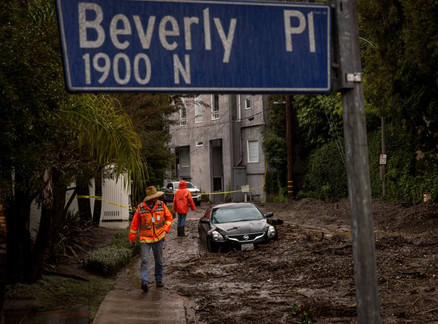 Workers survey a mudslide Tuesday, Feb. 6, 2024, in the Beverly Crest area of Los Angeles. (AP Photo/Ethan Swope)