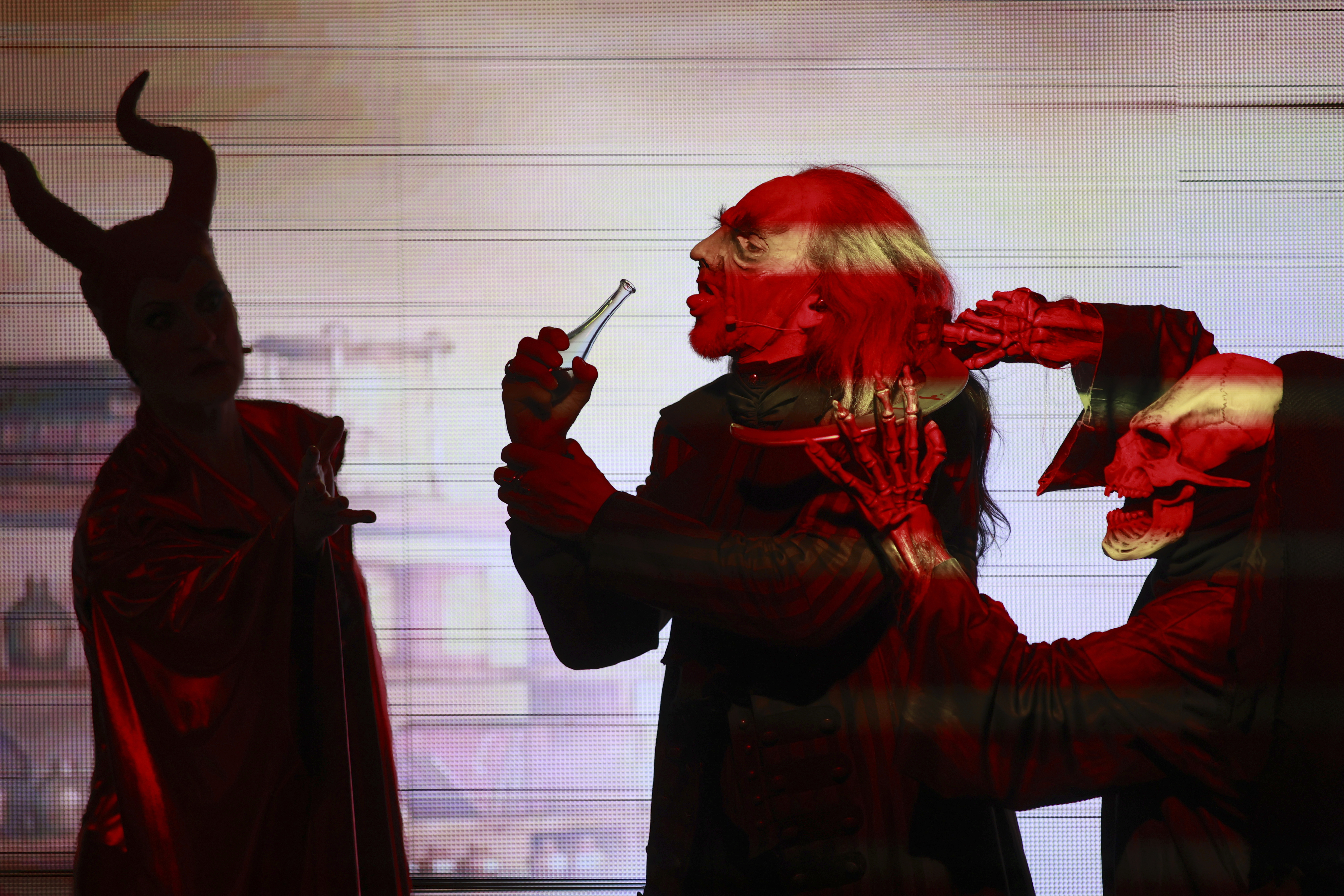 FILE - "Faust" actor Christian Venzke, center, stands next to Mephista actress Jessica Fendler, left, in a scene in Brocken, Germany, Friday, Nov. 3, 2023 .(Matthias Bein/dpa via AP, File)