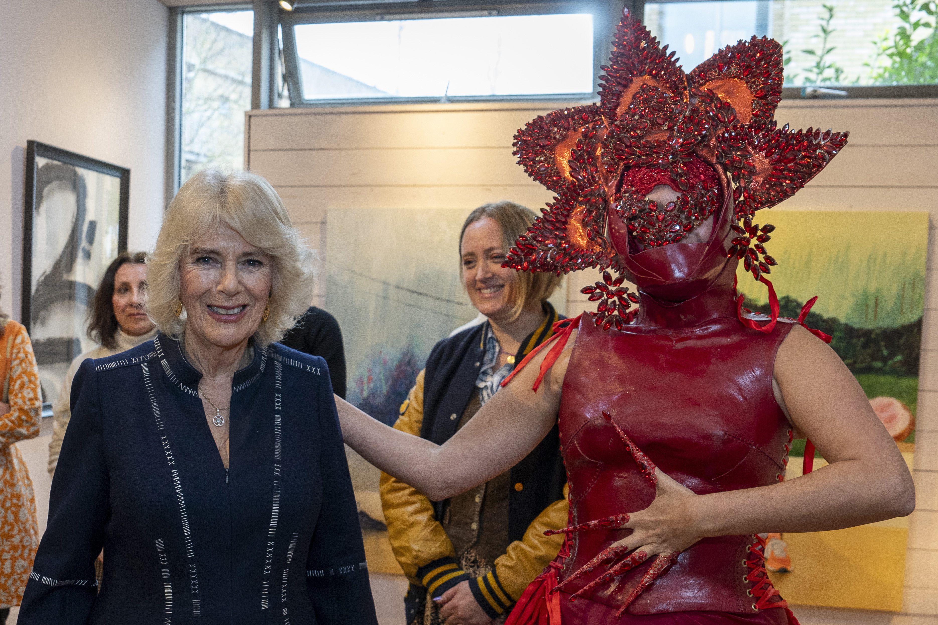 FILE - Britain's Queen Camilla, left, meets costume designer Syban Velardi-Laufer during her visit to Kindred Studios' Shepherds Bush pop-up hub, an art studios and creative space encouraging arts, crafts and community cohesion, in London, Wednesday, Feb. 14, 2024. Queen Camilla, once seen as the scourge of the House of Windsor, the woman at the heart of King Charles III’s doomed marriage to the late Princess Diana, has emerged as one of the monarchy’s most prominent emissaries. (Arthur Edwards/Pool Photo via AP, File)