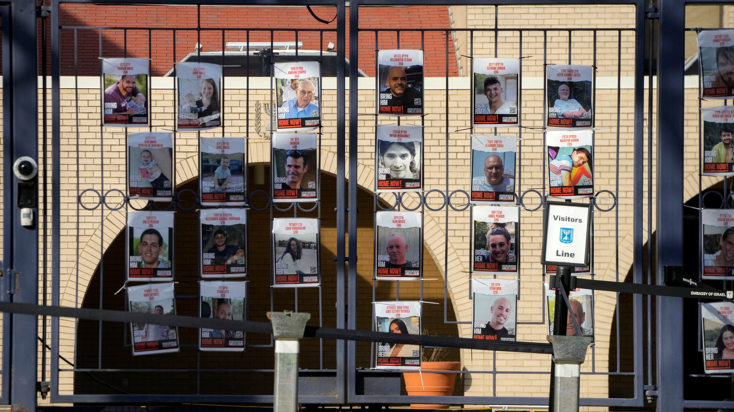 Posters of kidnapped people line the gates at the entrance of the Israeli Embassy, Monday, Feb. 26, 2024, in Washington. An active-duty member of the U.S. Air Force has died after he set himself ablaze outside the Israeli Embassy in Washington, D.C., while declaring that he "will no longer be complicit in genocide." (AP Photo/Mark Schiefelbein)