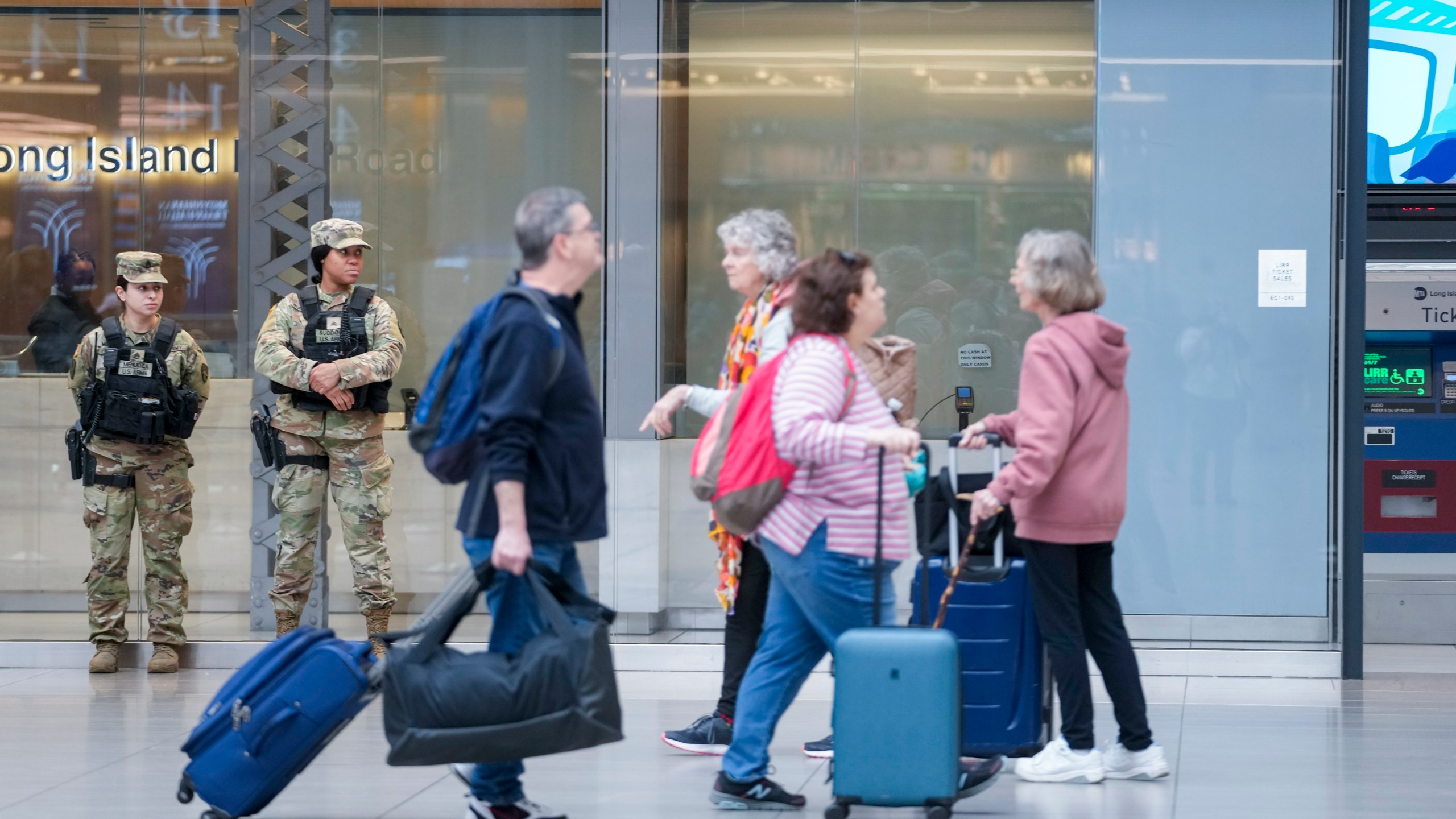 Commuters walk past a couple of New York National Guard soldiers stand guard a the Moynihan Train Hall at Penn Station, Thursday, March 7, 2024, in New York. New York Gov. Kathy Hochul announced plans Wednesday to send the National Guard to the New York City subway system to help police conduct random searches of riders' bags for weapons following a series of high-profile crimes on city trains. (AP Photo/Mary Altaffer)