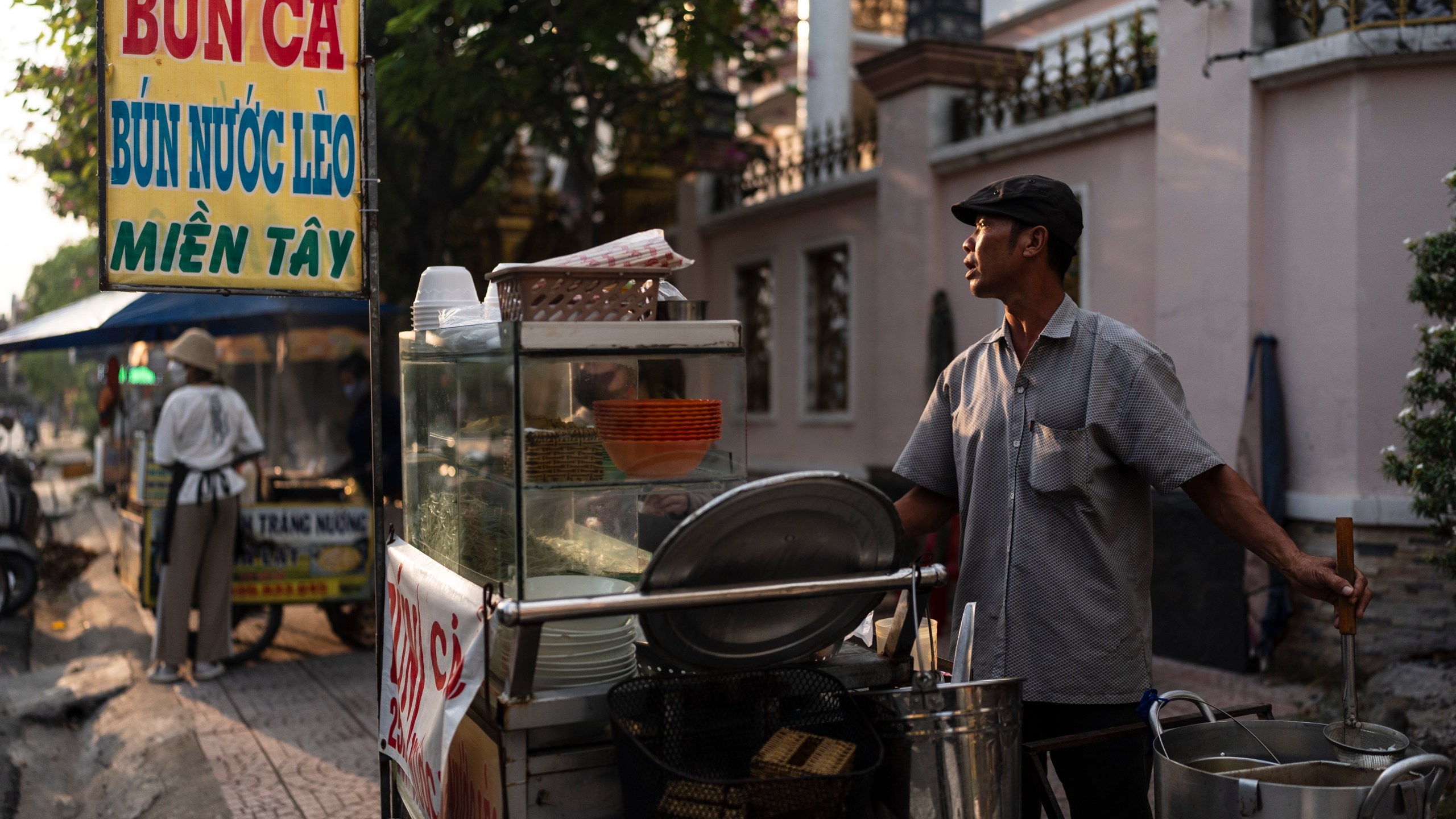 Pham Van Sang, a food vendor who migrated from the Mekong Delta, prepares a noodle dish at his food stall in Ho Chi Minh City, Vietnam, Monday, Jan. 22, 2024. He sells noodles in the city's industrial zone, a destination for many migrants from the Mekong Delta seeking a better life. (AP Photo/Jae C. Hong)