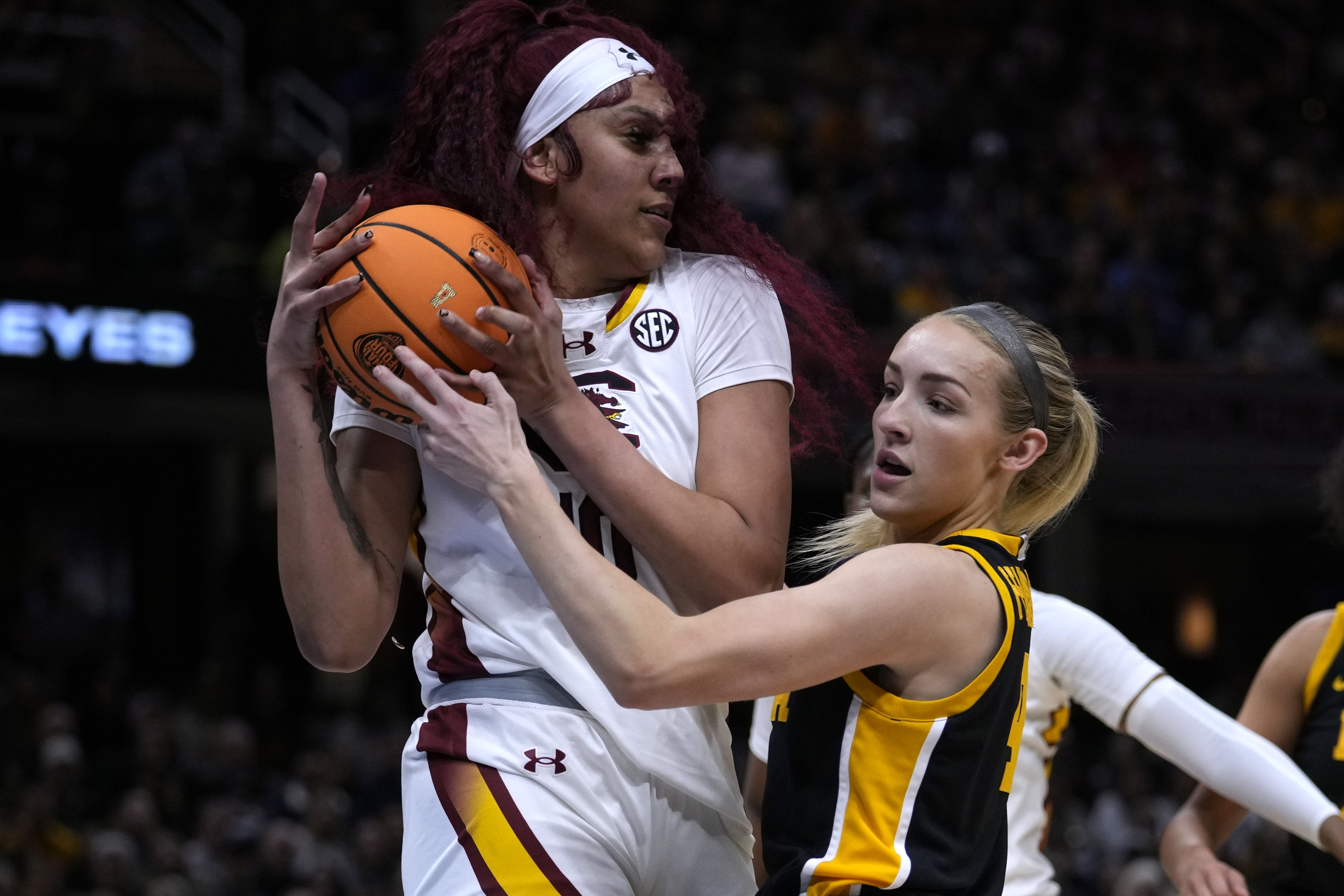 South Carolina center Kamilla Cardoso grabs a rebound over Iowa guard Kylie Feuerbach, right, during the first half of the Final Four college basketball championship game in the women's NCAA Tournament, Sunday, April 7, 2024, in Cleveland. (AP Photo/Carolyn Kaster)