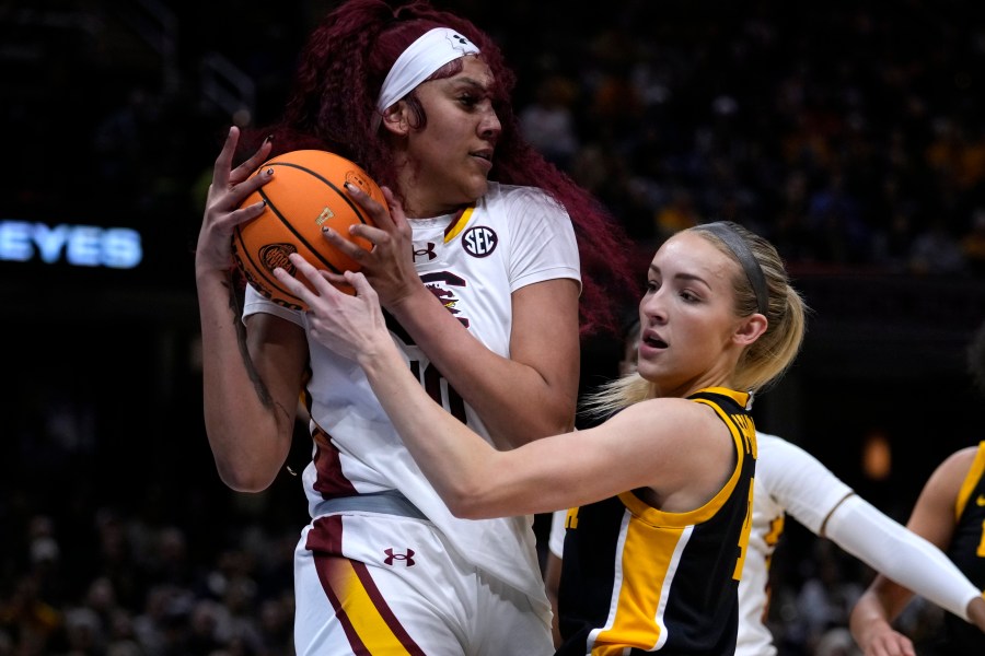 South Carolina center Kamilla Cardoso grabs a rebound over Iowa guard Kylie Feuerbach, right, during the first half of the Final Four college basketball championship game in the women's NCAA Tournament, Sunday, April 7, 2024, in Cleveland. (AP Photo/Carolyn Kaster)