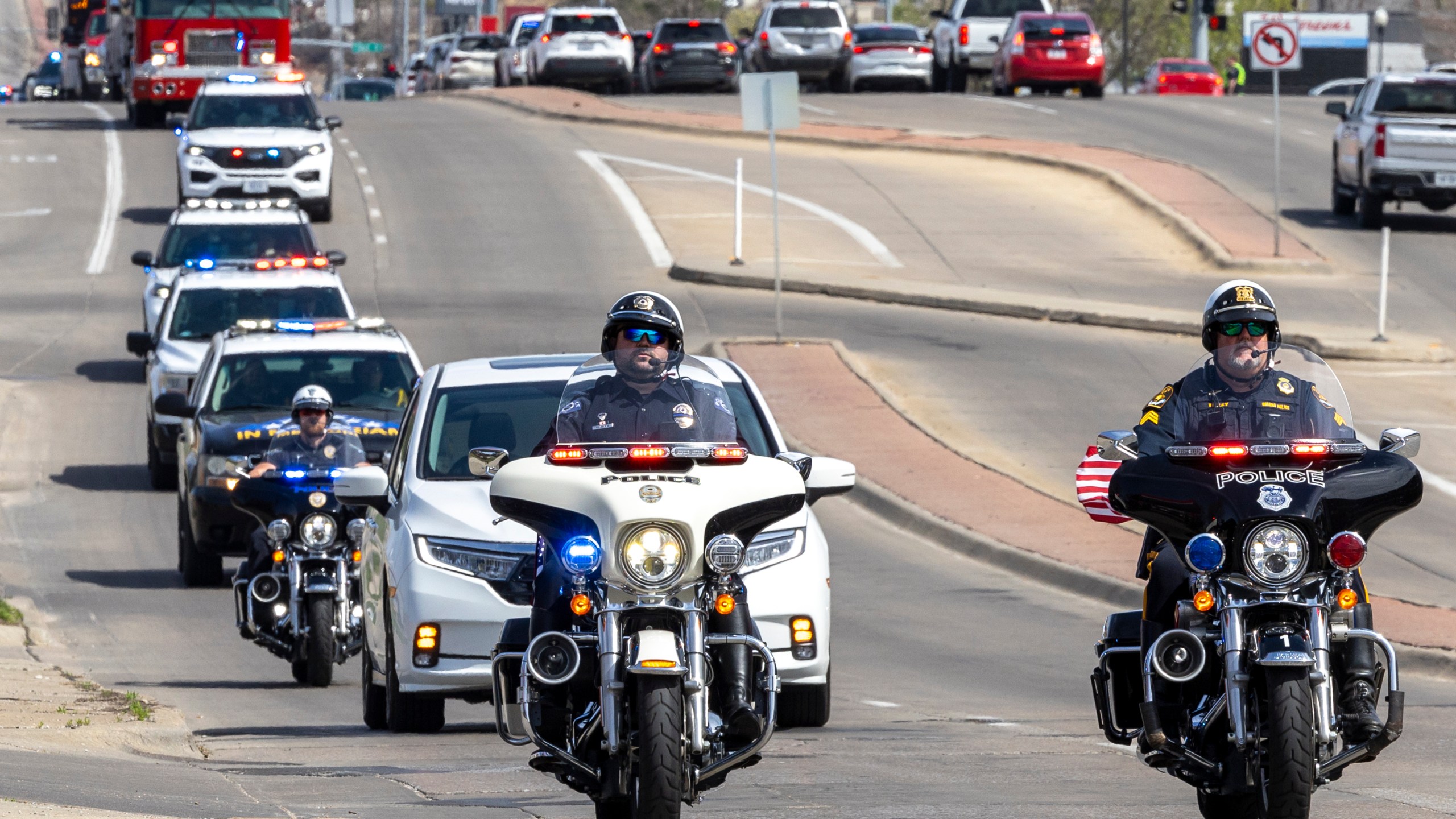 Nebraska law enforcement holds a procession to escort fallen Ceresco Officer Ross Bartlett, Saturday, April 13, 2024, in Lincoln, Neb. The veteran police officer was killed when his cruiser was struck by another vehicle after he made a traffic stop in eastern Nebraska, authorities said Saturday. (Justin Wan/Lincoln Journal Star via AP)