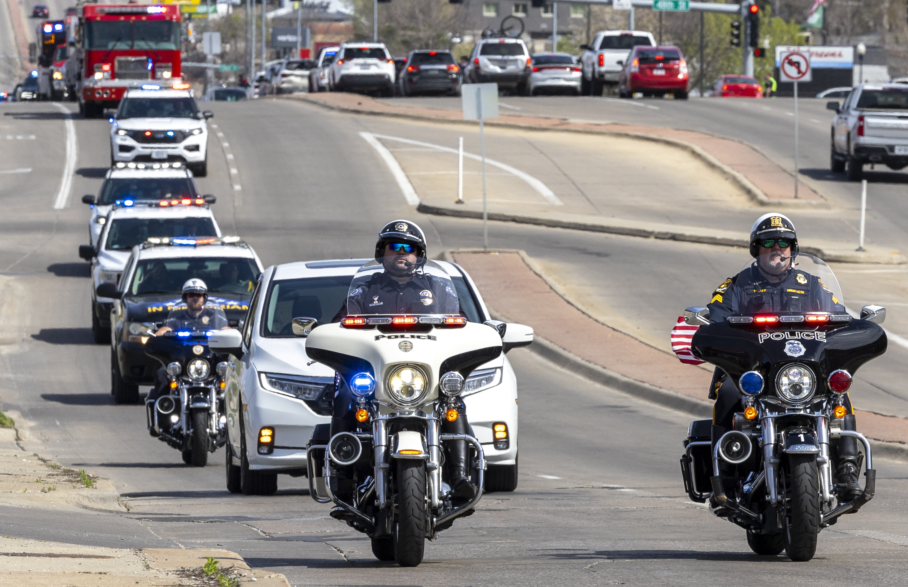 Nebraska law enforcement holds a procession to escort fallen Ceresco Officer Ross Bartlett, Saturday, April 13, 2024, in Lincoln, Neb. The veteran police officer was killed when his cruiser was struck by another vehicle after he made a traffic stop in eastern Nebraska, authorities said Saturday. (Justin Wan/Lincoln Journal Star via AP)