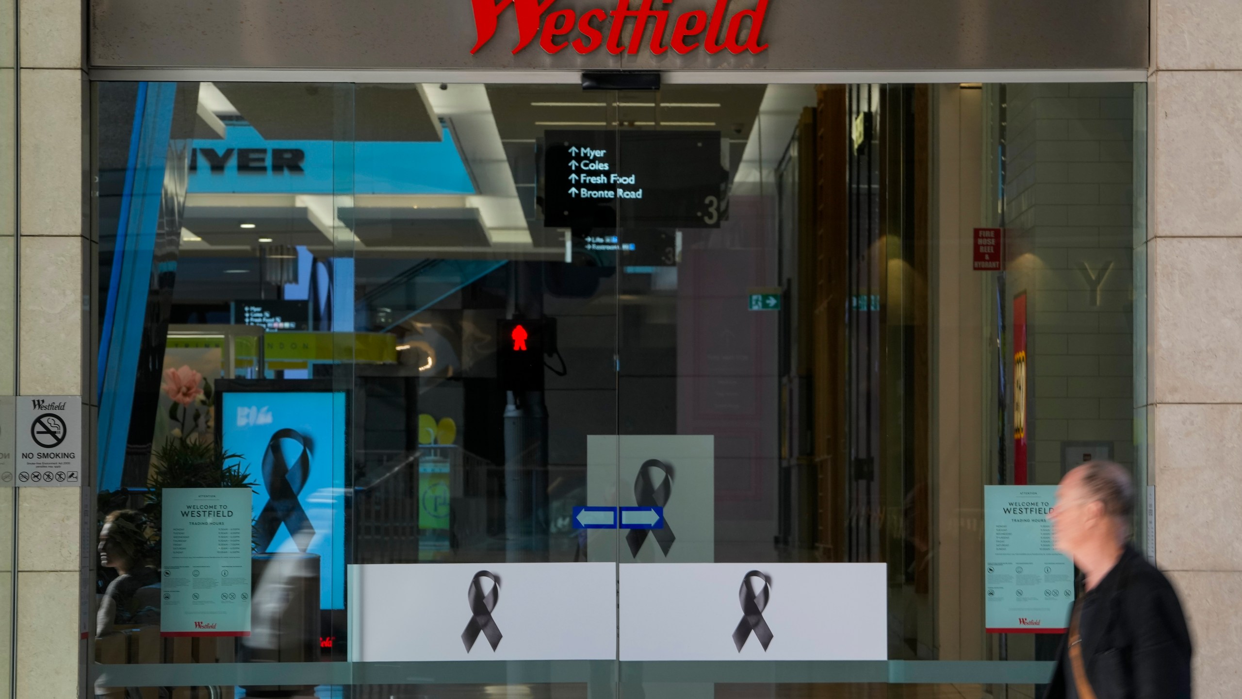 A man walks past the entrance to the Westfield mall at Bondi Junction in Sydney, Thursday, April 18, 2024. The Sydney shopping mall has been opened to the public for the first time since it became the scene of a mass stabbing in which six people died, while the Australian prime minister has flagged giving citizenship to an immigrant security guard who was injured while confronting the knife-wielding attacker. (AP Photo/Mark Baker)