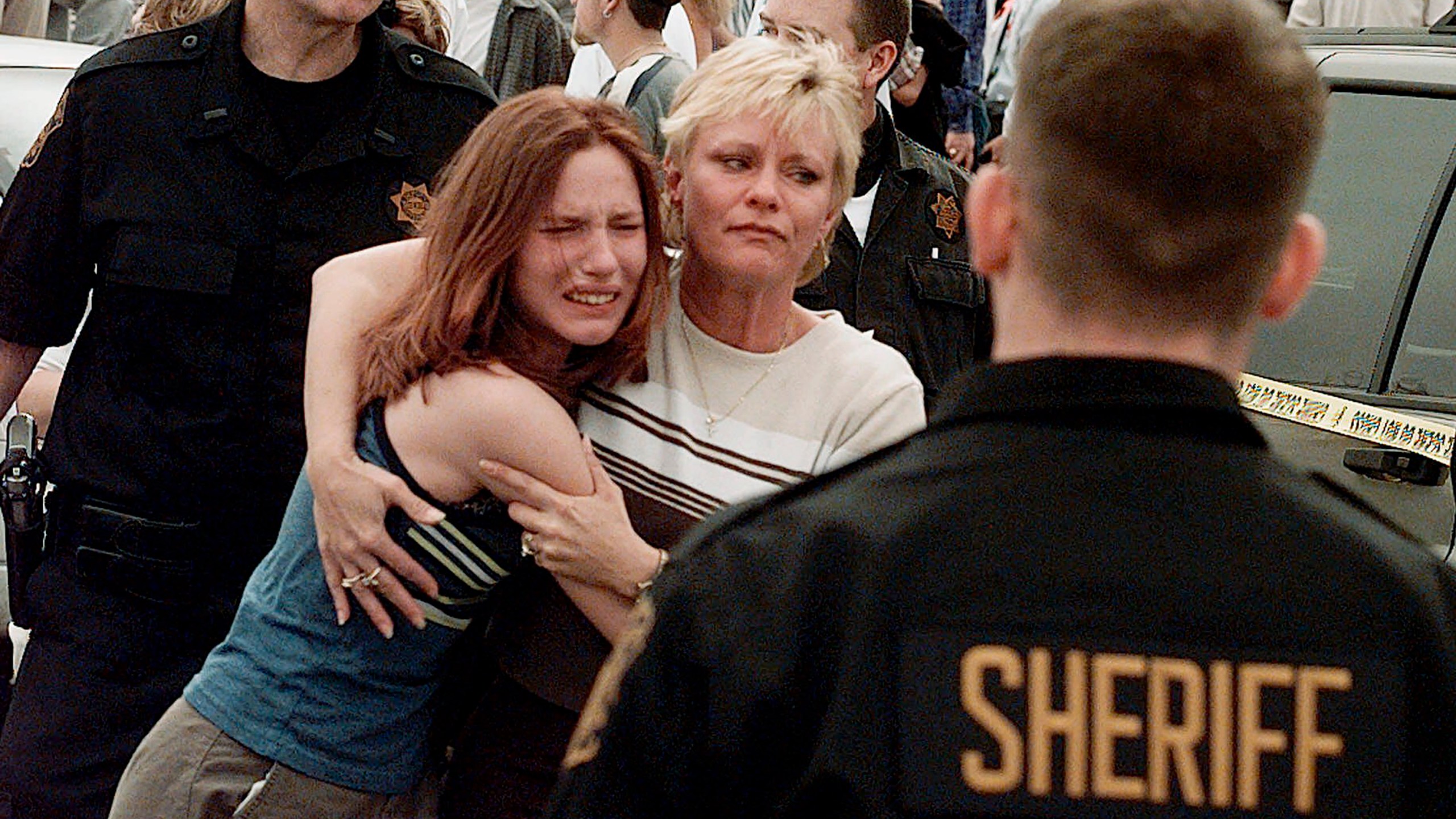 FILE - A woman embraces her daughter after they were reunited following a shooting at Columbine High School in Littleton, Colo., on April, 20, 1999. Twenty-five years later, The Associated Press is republishing this story about the attack, the product of reporting from more than a dozen AP journalists who conducted interviews in the hours after it happened. The article first appeared on April 22, 1999. (AP Photo/Ed Andrieski, File)