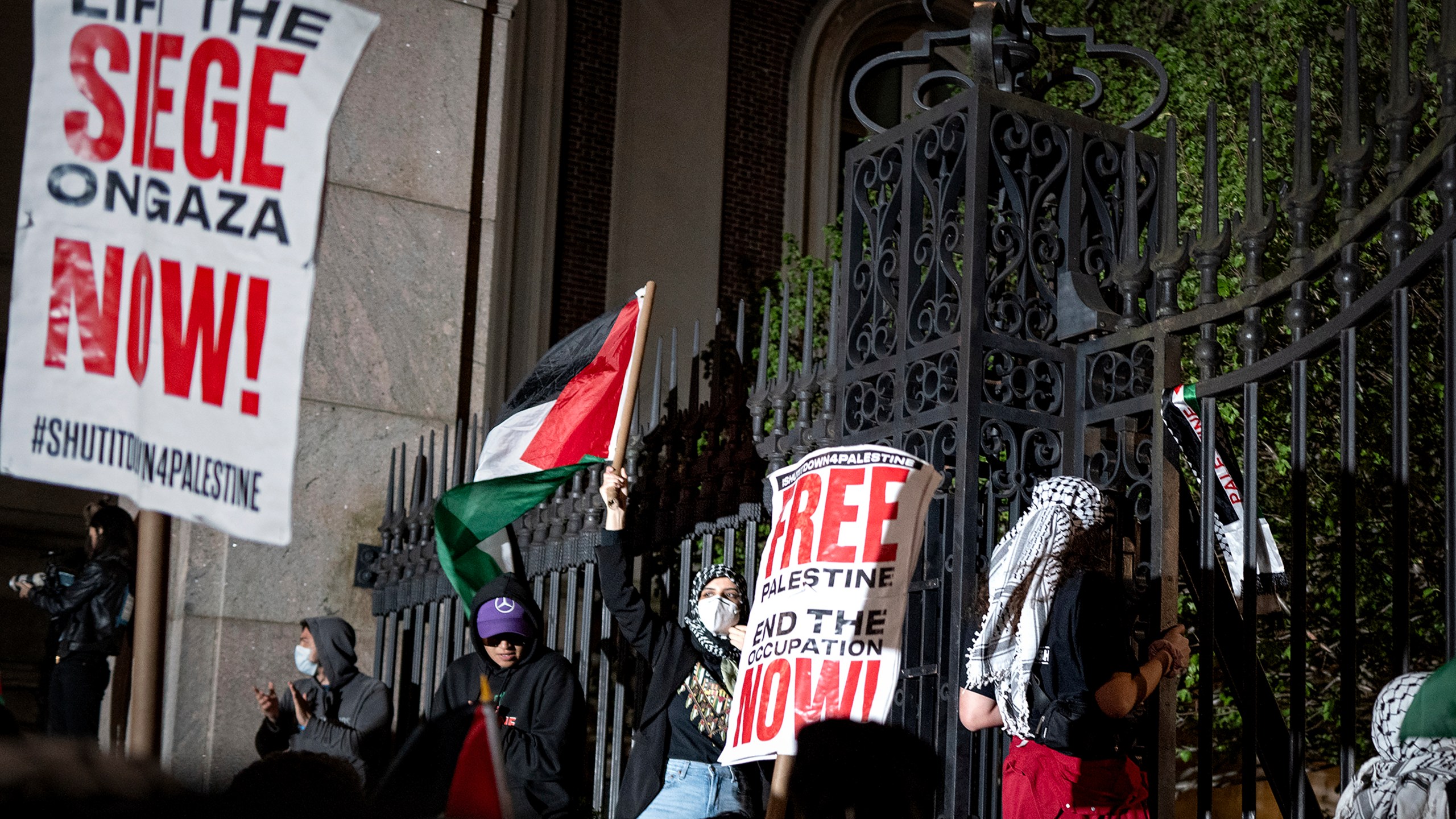 Pro-Palestianian protesters gather near a main gate at Columbia University in New York, Tuesday, April 30, 2024, just before New York City police officers cleared the area after a building was taken over by protesters earlier in the day. The building and a tent encampment were cleared during the operation. (AP Photo/Craig Ruttle)