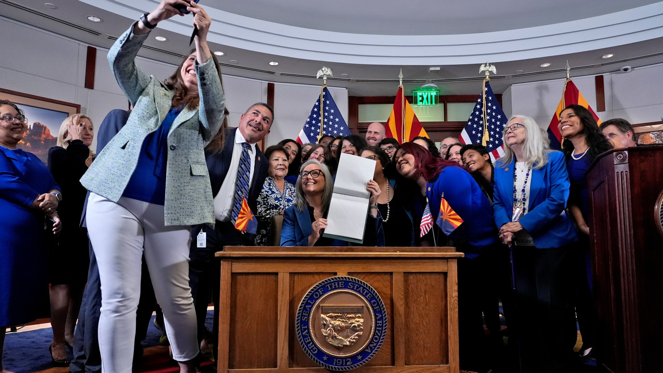 Ariz.. Rep. Stephanie Stahl Hamilton, takes a selfie with Arizona Gov. Katie Hobbs, after Hobbs signed the repeal of the Civil War-era near-total abortion ban to Thursday, May 2, 2024, at the Capitol in Phoenix. Democrats secured enough votes in the Arizona Senate to repeal the ban on abortions that the state's highest court recently allowed to take effect. (AP Photo/Matt York)