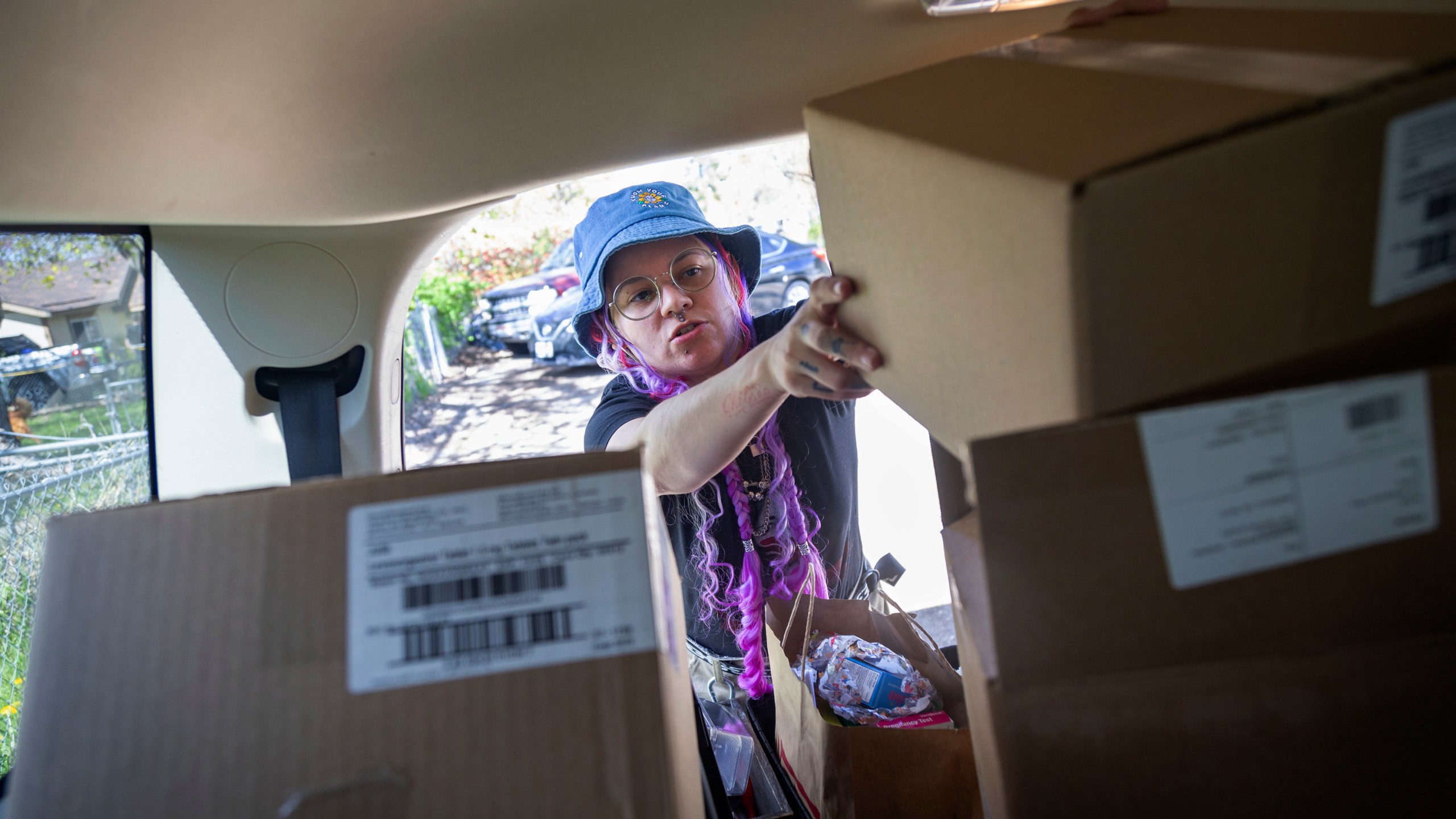 Kimra Luna fills the back of their car with boxes of materials which will be used to make reproductive health kits which are then offered free to local business in Boise, Idaho, on Friday, April 12, 2024. Luna, a doula and reproductive care activist, lives in a state with some of the strictest abortion laws in the nation. (AP Photo/Kyle Green)
