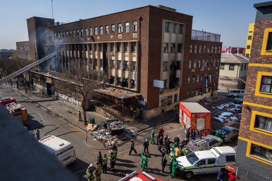 FILE - Medics and emergency works at the scene of a deadly blaze in Johannesburg Thursday, Aug. 31, 2023. A report into a building fire that killed 76 people in South Africa last year has concluded that city authorities should be held responsible because they were aware of serious safety issues at the rundown apartment block at least four years before the blaze. The nighttime fire at the five-story building in downtown Johannesburg on Aug. 31 was one of South Africa's worst disasters. At least 12 children were among the dead and another 86 people were injured. (AP Photo/Jerome Delay, File)