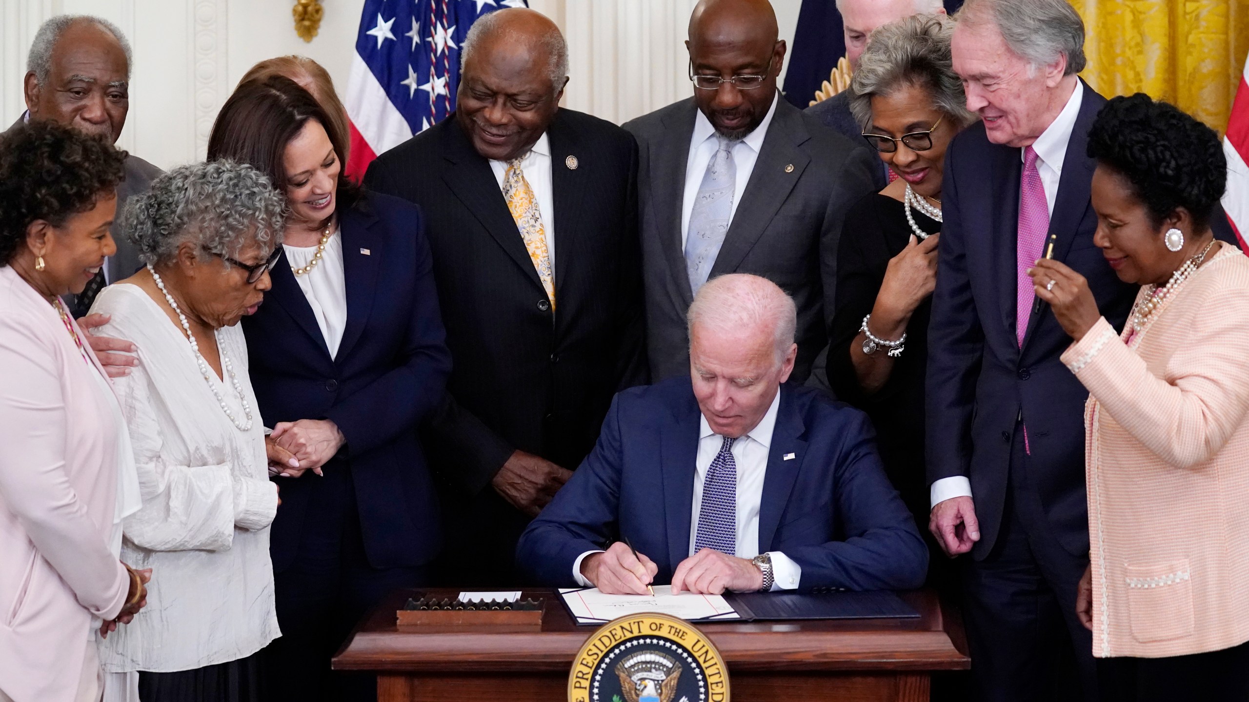 FILE - President Joe Biden signs the Juneteenth National Independence Day Act, in the East Room of the White House, Thursday, June 17, 2021, in Washington. From left, Rep. Barbara Lee, D-Calif, Rep. Danny Davis, D-Ill., Opal Lee, Sen. Tina Smith, D-Minn., obscured, Vice President Kamala Harris, House Majority Whip James Clyburn of S.C., Sen. Raphael Warnock, D-Ga., Sen. John Cornyn, R-Texas, Rep. Joyce Beatty, D-Ohio, Sen. Ed Markey, D-Mass., and Rep. Sheila Jackson Lee, D-Texas. (AP Photo/Evan Vucci, File)