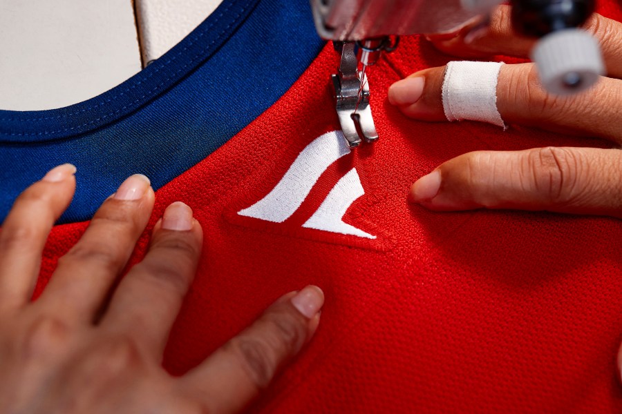 In this handout provided by Fanatics, a Fanatics logo is sewn on the back of a Florida Panthers NHL hockey jersey at the SP Apparel factory in Saint-Hyacinthe, Quebec, Tuesday, June 11, 2024. The NHL unveils new player jerseys for the 2024-25 season made by Fanatics, Wednesday, June 26, 2024, the first time the company has designed and manufactured on-ice/field/court uniforms for a major professional sports league. (Photo courtesy Fanatics via AP)