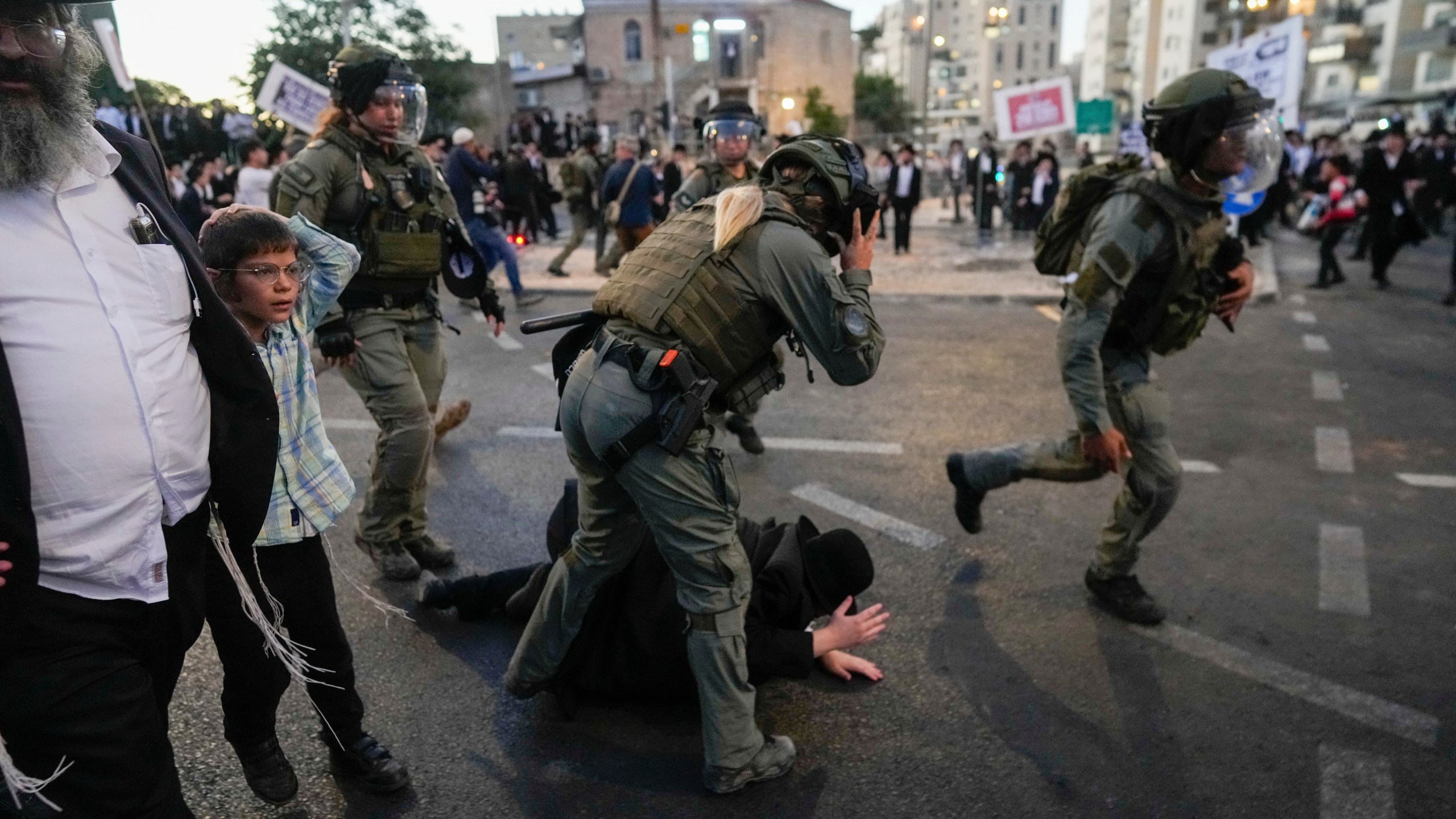 Ultra-Orthodox Jewish men clash with police during a rally against army recruitment in Jerusalem on Sunday, June 30, 2024. Israel's Supreme Court last week ordered the government to begin drafting ultra-Orthodox men into the army, a landmark ruling seeking to end a system that has allowed them to avoid enlistment into compulsory military service. (AP Photo/Ohad Zwigenberg)