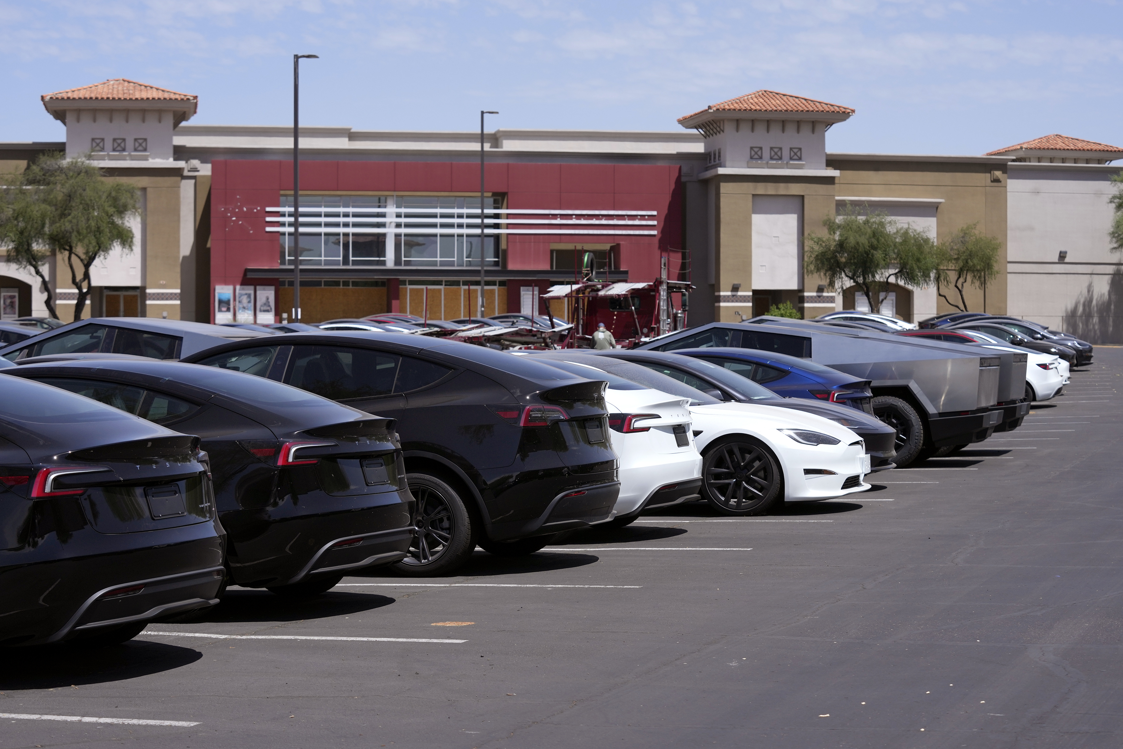 Tesla vehicles are stored at a shopping mall parking lot near a closed movie theater Friday, June 21, 2024, in Scottsdale, Ariz. (AP Photo/Ross D. Franklin)