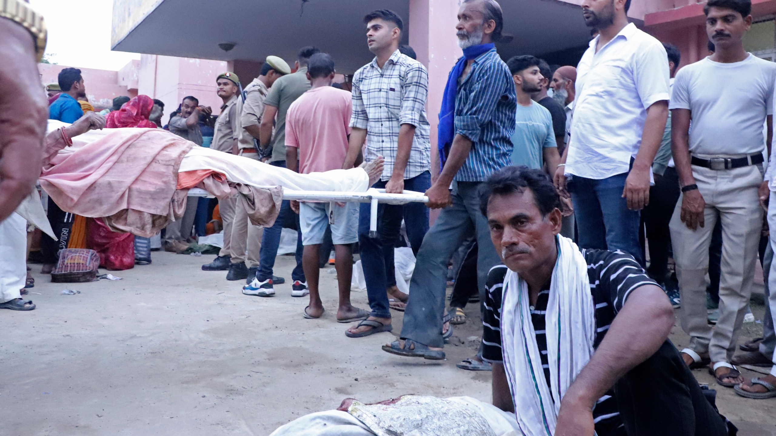 Relatives carry body of a man on a stretcher outside the Sikandrarao hospital in Hathras district about 350 kilometers (217 miles) southwest of Lucknow, India, Tuesday, July 2, 2024. At least 60 people are dead and scores are injured after a stampede at a religious gathering of thousands of people in northern India, officials said Tuesday.(AP Photo/Manoj Aligadi)