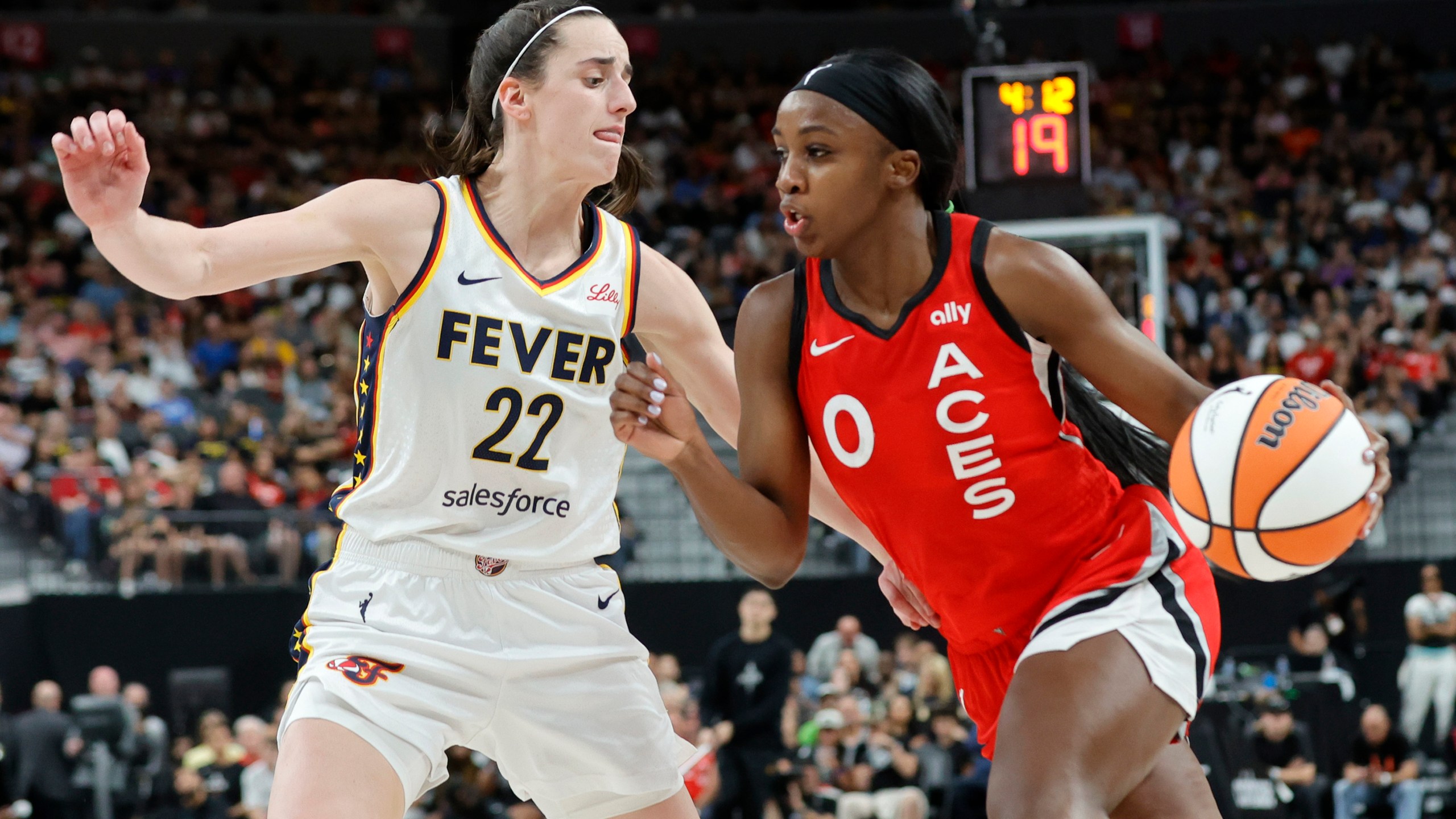 Indiana Fever guard Caitlin Clark (22) defends against Las Vegas Aces guard Jackie Young (0) during the first half of an WNBA basketball game Tuesday, July 2, 2024, in Las Vegas. (Steve Marcus/Las Vegas Sun via AP)