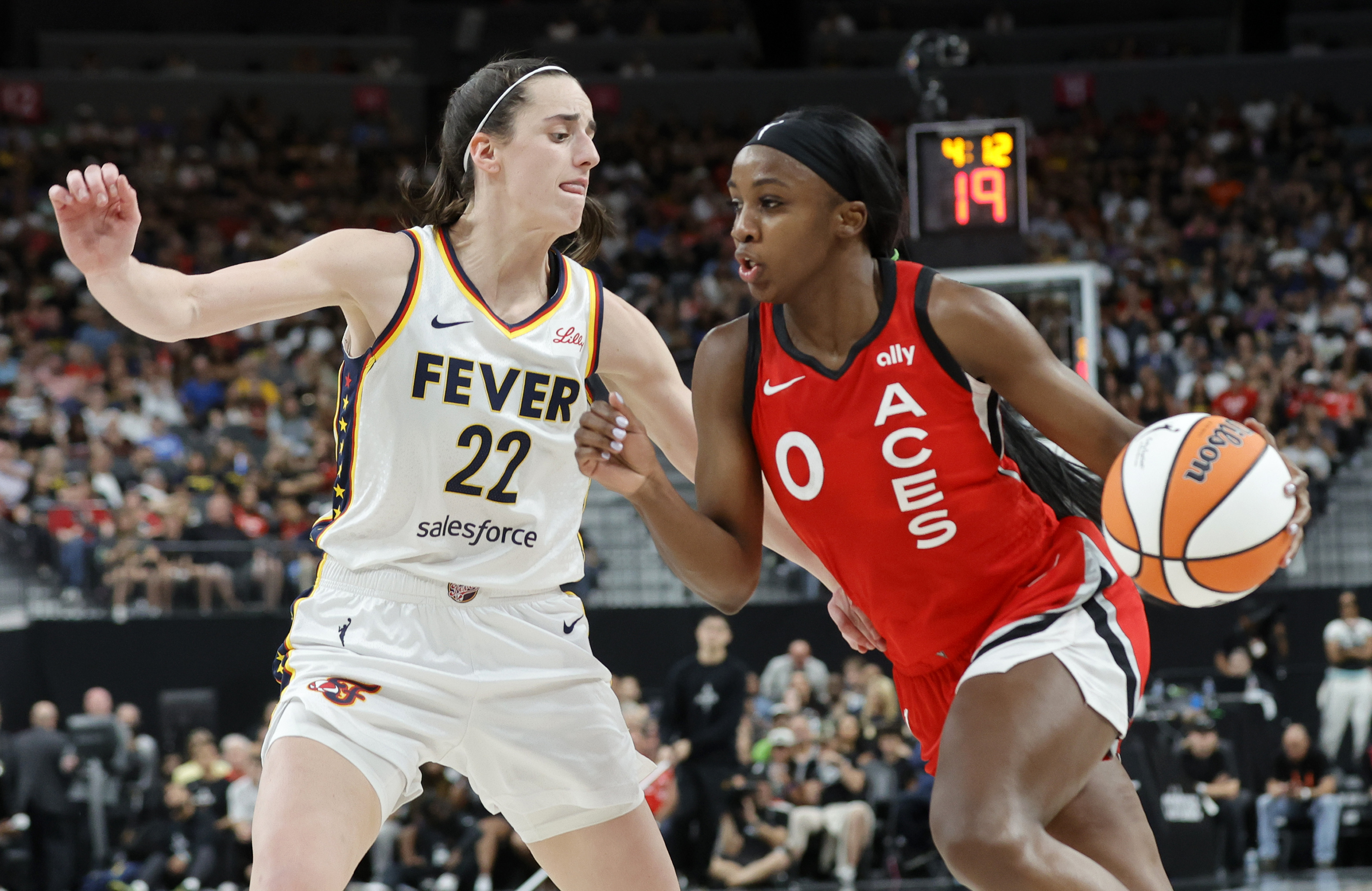 Indiana Fever guard Caitlin Clark (22) defends against Las Vegas Aces guard Jackie Young (0) during the first half of an WNBA basketball game Tuesday, July 2, 2024, in Las Vegas. (Steve Marcus/Las Vegas Sun via AP)
