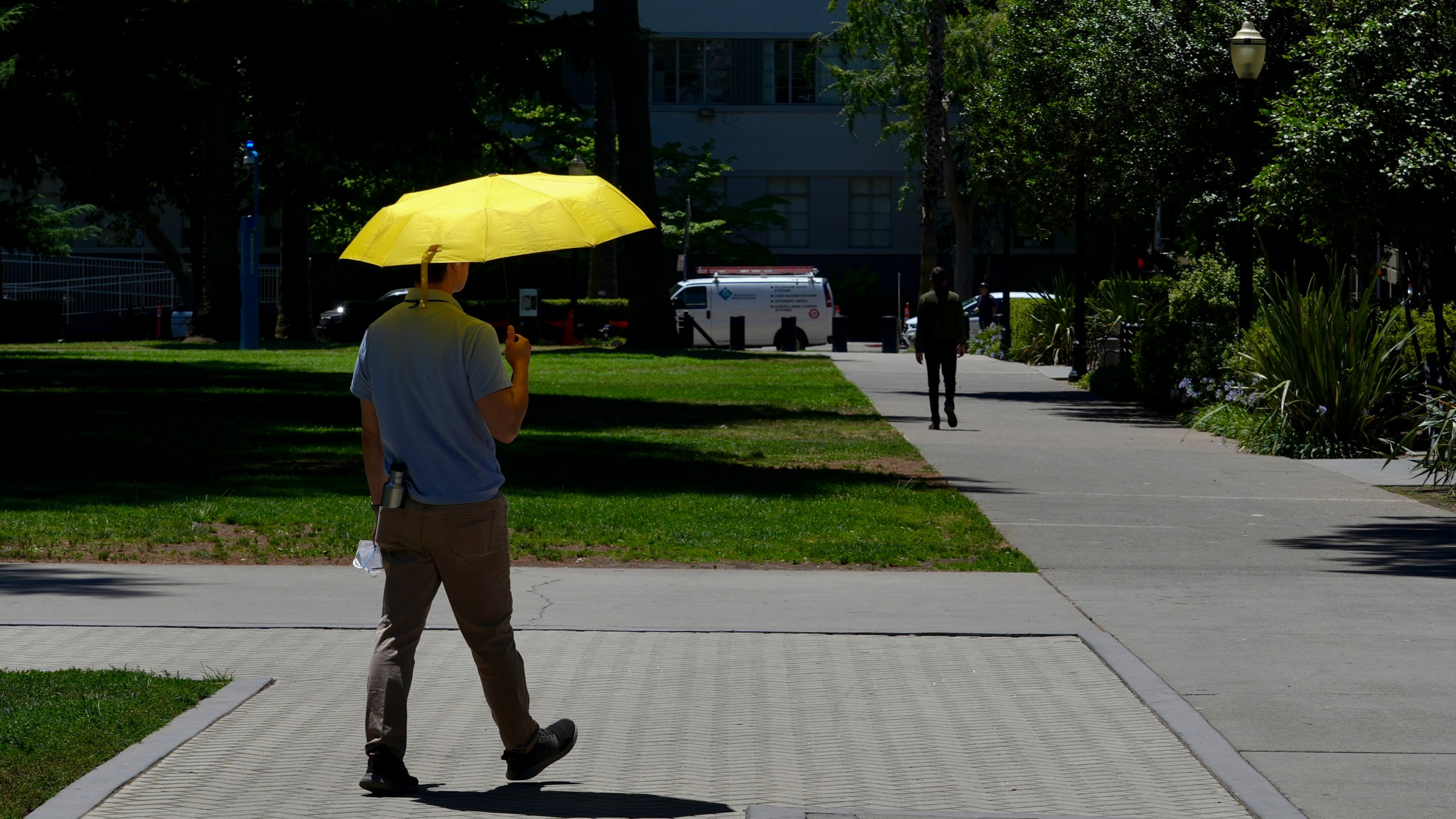 A man shields himself from the sun in Sacramento, Calif., Tuesday, July 2, 2024. . (AP Photo/Terry Chea)