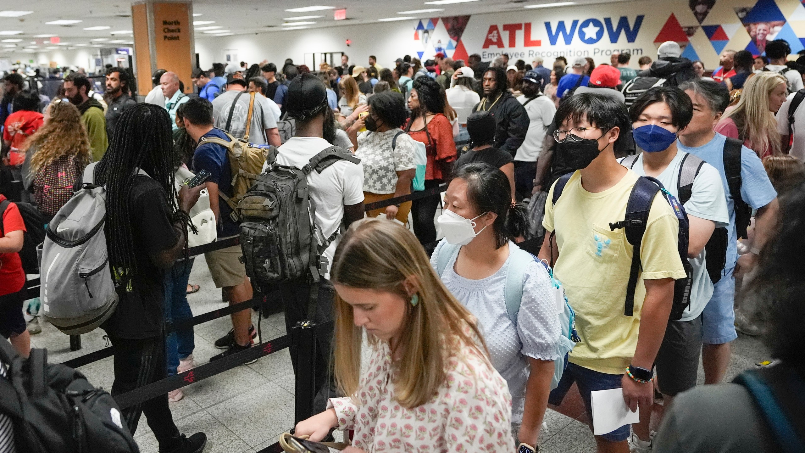 FILE - Travelers line up for security clearance at Hartsfield-Jackson Atlanta International Airport on Friday, June 28, 2024, in Atlanta. Travel activity is expected to heat up to record levels around the Independence Day holiday as consumers take advantage of cooler prices for airfares, gasoline and hotels. (AP Photo/Pablo Martinez Monsivais, File)