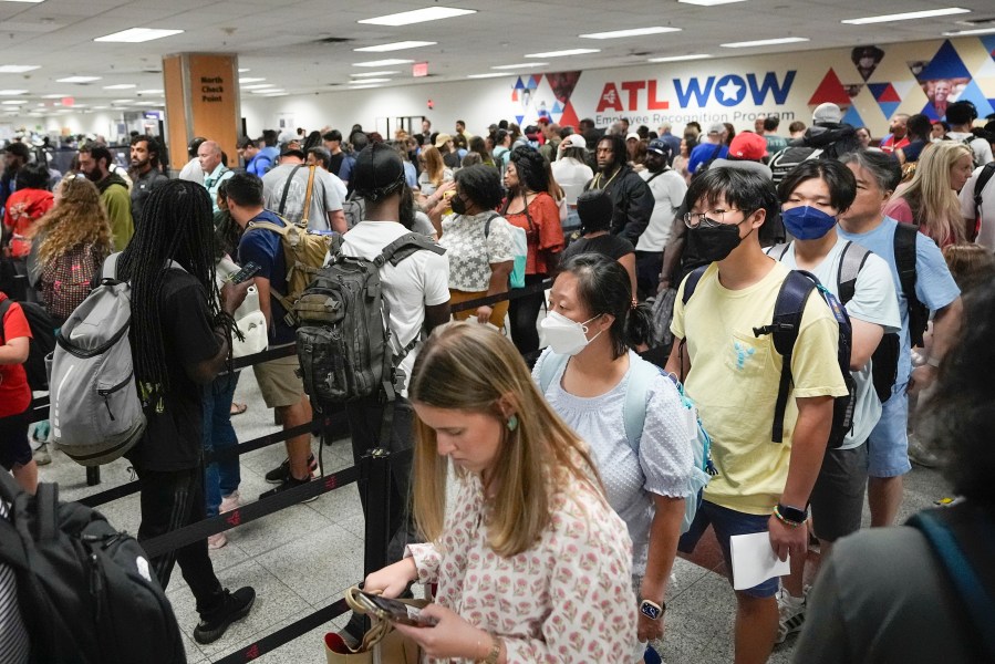 FILE - Travelers line up for security clearance at Hartsfield-Jackson Atlanta International Airport on Friday, June 28, 2024, in Atlanta. Travel activity is expected to heat up to record levels around the Independence Day holiday as consumers take advantage of cooler prices for airfares, gasoline and hotels. (AP Photo/Pablo Martinez Monsivais, File)