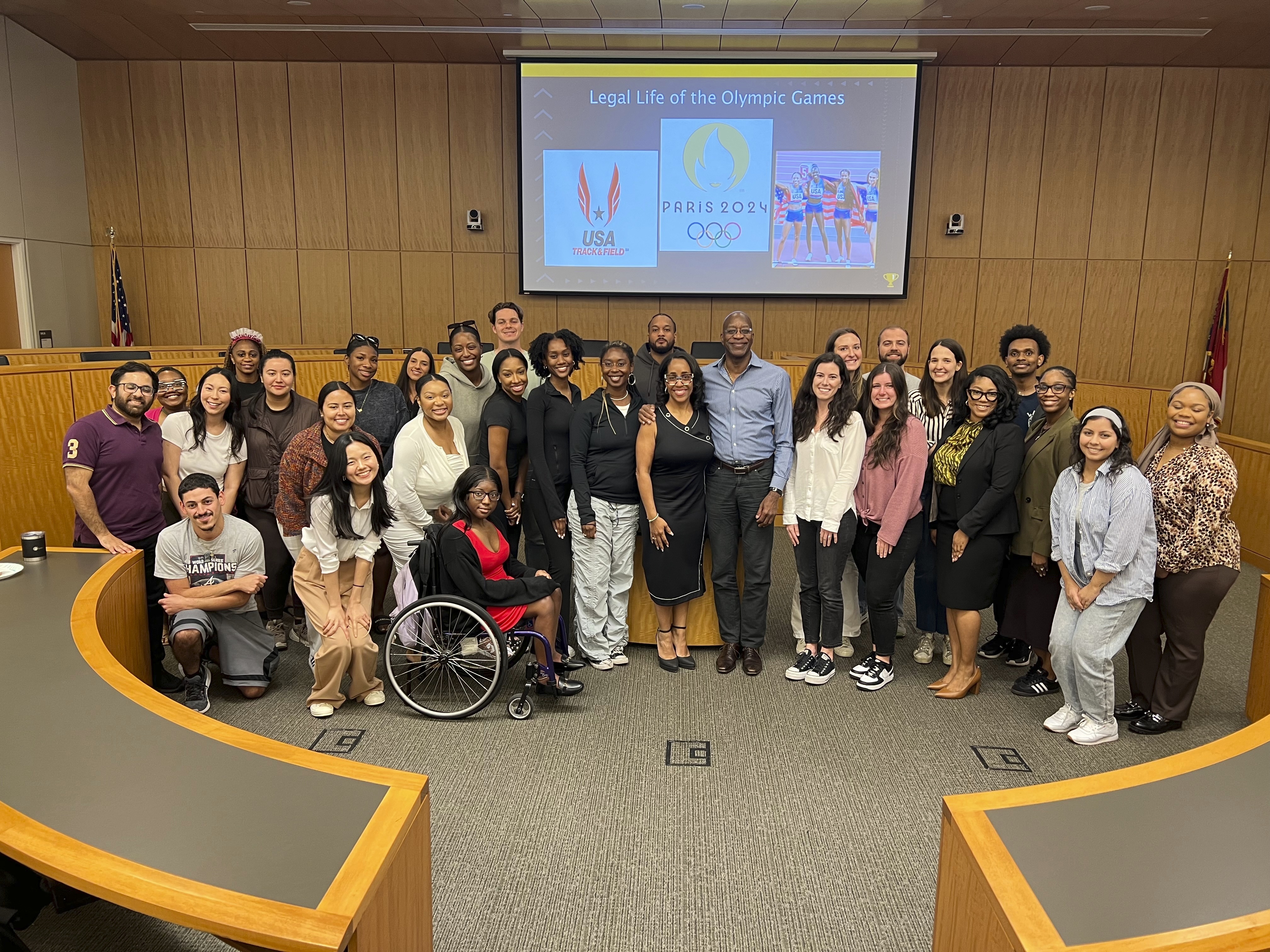 This image released by Georgia State University shows law professor Moraima “Mo” Ivory, center, left, posing with Olympian Edwin Moses, center, right, and her Legal Life class at Georgia State University in Atlanta. Ivory is known for bringing celebrities like Steve Harvey and Ludacris into her law class. But now she's taking her Atlanta law students on a free trip to the Paris Olympics this summer in hopes of creating real-life teachable moments. (Haley Austin/Georgia State University via AP)