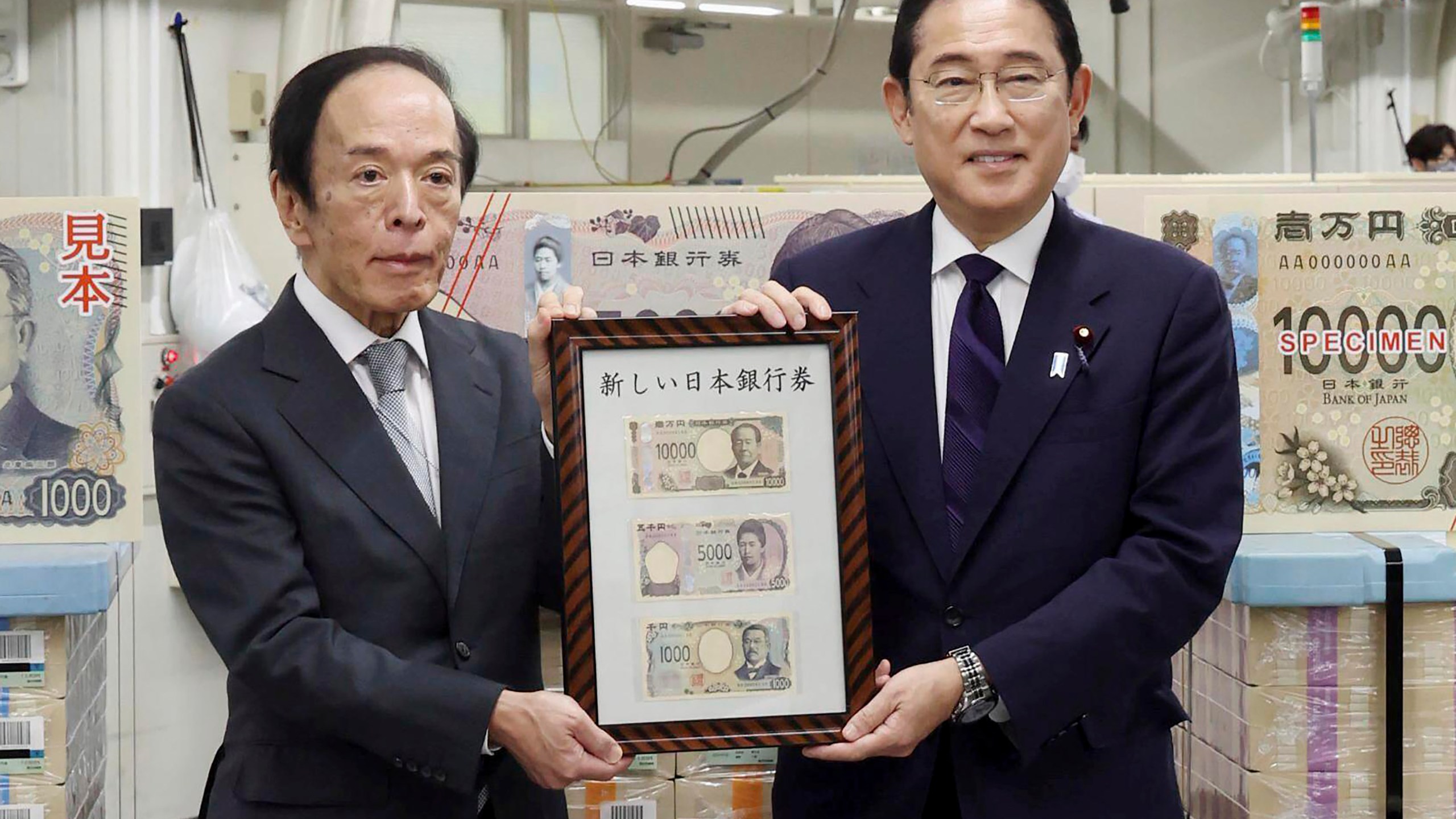 Japanese Prime Minister Fumio Kishida, right, and Bank of Japan Governor Kazuo Ueda hold the country’s new banknotes in a frame, during a ceremony to mark the release of the banknotes, at the BOJ headquarters in Tokyo, Japan, Wednesday, July 3, 2024. (Japan Pool/Kyodo News via AP)