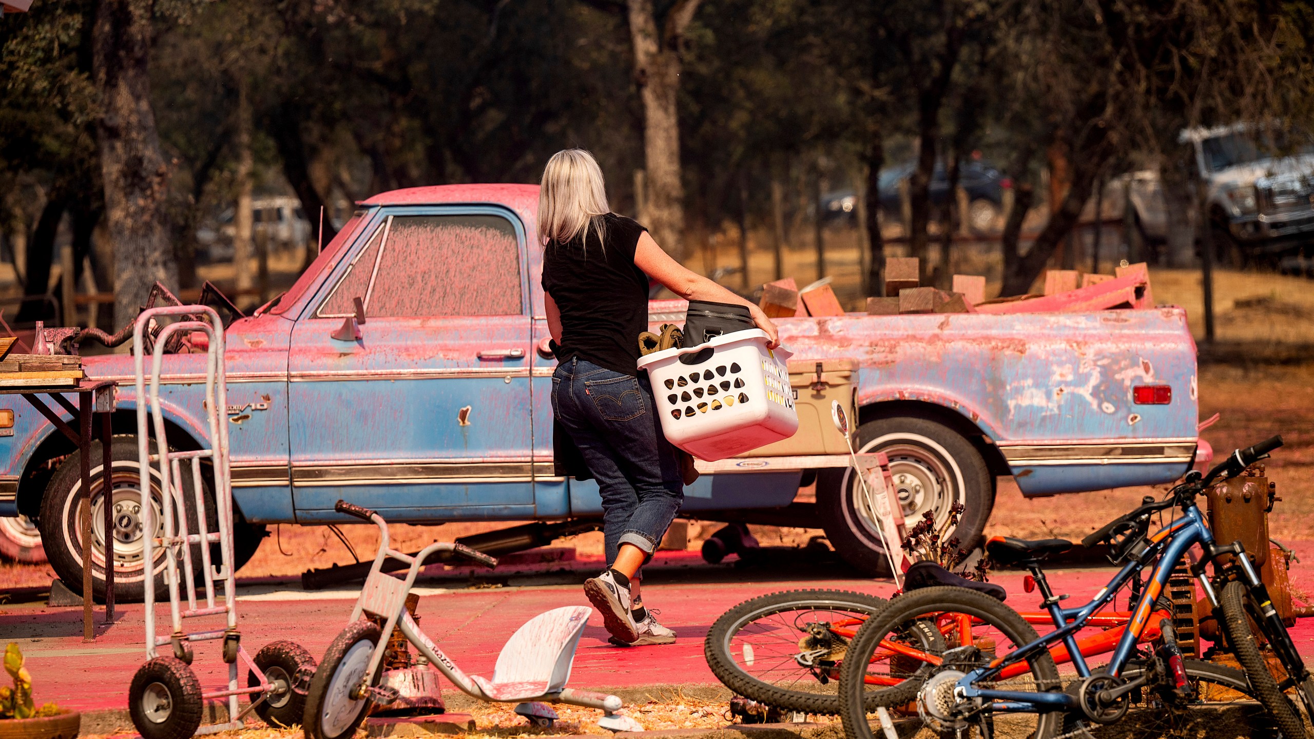 Cindy Miller moves belongings from her home as the Grubbs Fire burns in the Palermo community of Butte County, Calif., on Wednesday, July 3, 2024. (AP Photo/Noah Berger)