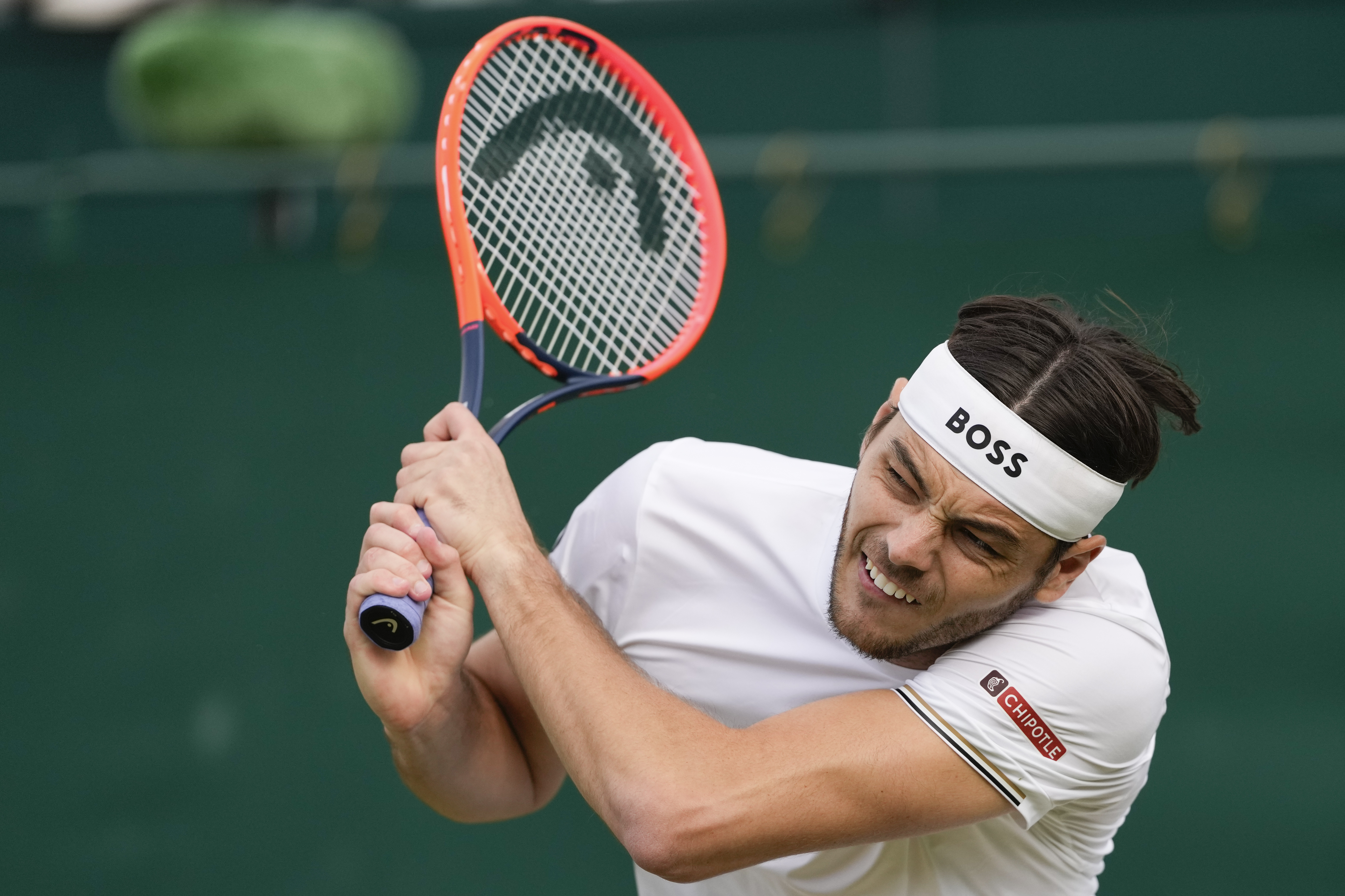 Taylor Fritz of the United States plays a backhand return to Arthur Rinderknech of France during their second round match at the Wimbledon tennis championships in London, Thursday, July 4, 2024. (AP Photo/Alberto Pezzali)