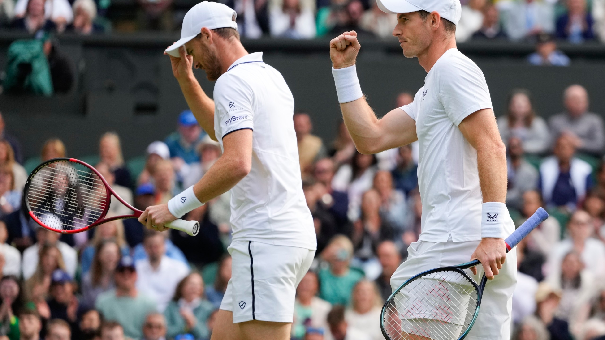 Andy, right, and Jamie Murray react during their first round doubles match against Australia's John Peers and Ricky Hijikata at the Wimbledon tennis championships in London, Thursday, July 4, 2024. (AP Photo/Kirsty Wigglesworth)