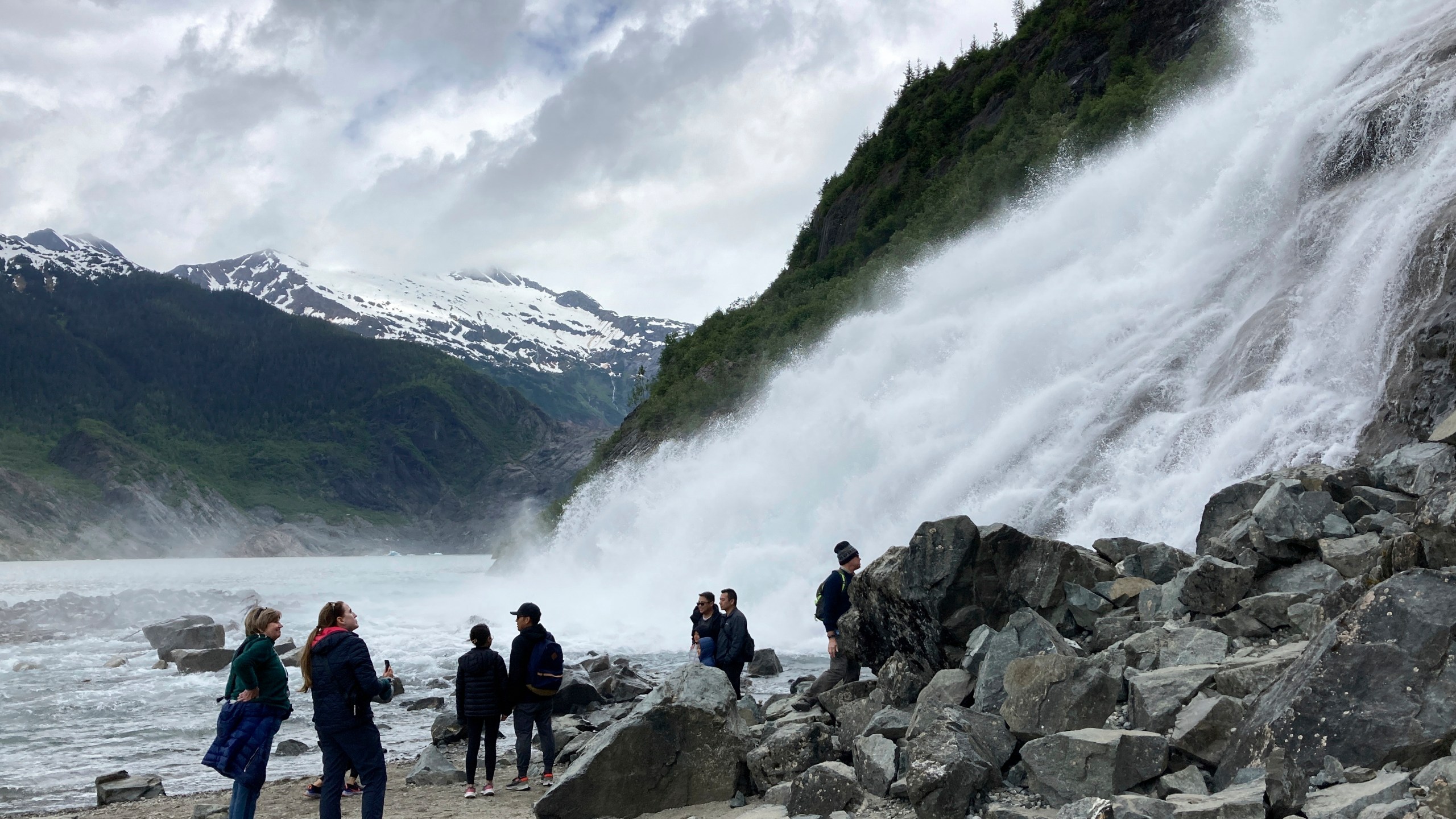 FILE - People gather near the base of Nugget Falls, a popular destination for selfies on June 13, 2023, at the Mendenhall Glacier Recreation Area, in Juneau, Alaska. Voters in Alaska's capital city could decide in October whether to ban large cruise ships on Saturdays starting next year. Supporters of the proposal say it would give residents a reprieve from the crush of tourists drawn to attractions like Juneau's fast-retreating Mendenhall Glacier, but opponents say it would hurt local businesses and invite lawsuits. (AP Photo/Becky Bohrer, File)