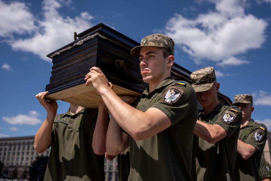 Ukrainian servicemen carry a coffin of British combat medic, volunteer, Peter Fouche, 49 who was killed on June 27 during his work in East Ukraine, at the funeral ceremony on the city's main square in Kyiv, Ukraine, Saturday, July 6, 2024. Peter was founder of a charity organization, which provides vehicles, drones and other needs to Ukrainian servicemen. (AP Photo/Alex Babenko)