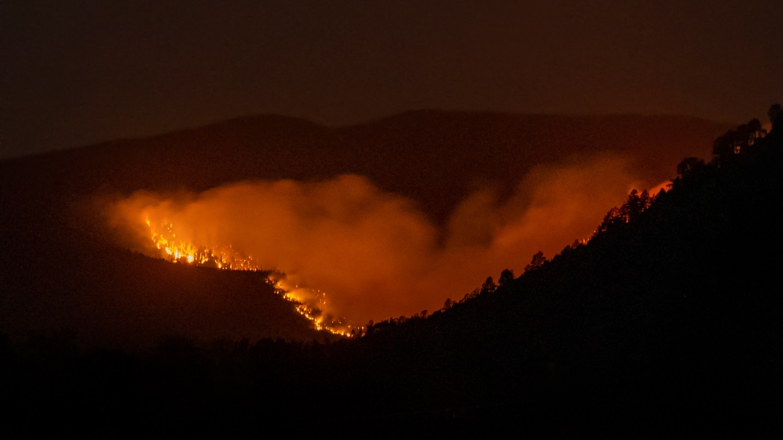 FILE - The Hermits Peak-Calf Canyon Fire burns south of Las Vegas, N.M., Saturday, May 7, 2022. Two years after the U.S. Forest Service sparked what would become the largest and most destructive wildfire in New Mexico’s recorded history, independent investigators say there are gaps that need to be addressed if the agency is to be successful at using prescribed fire as a tool to reduce risk amid climate change. (Robert Browman/The Albuquerque Journal via AP, File)