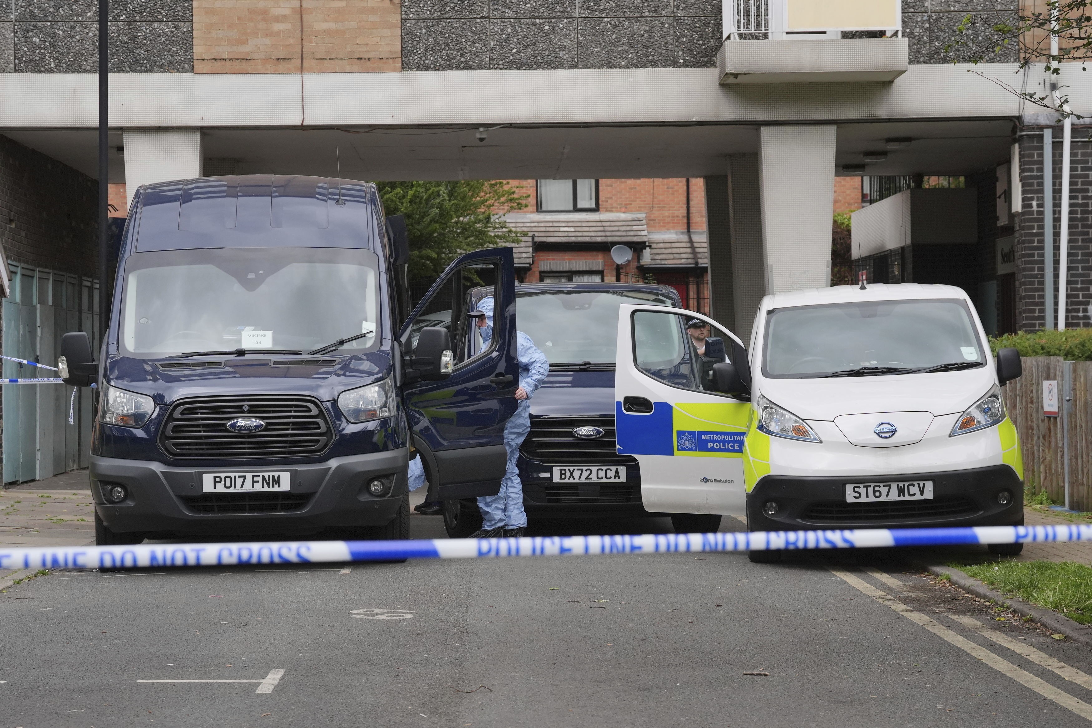 Forensic officers at the scene at an address in Shepherd's Bush, after human remains were found in two suitcases near the Clifton Suspension Bridge in Bristol, Saturday, July 13, 2024, in London. Police said human remains were found at an address in Shepherd's Bush, west London believed to be connected to those found in the suitcases dumped near the Clifton Suspension Bridge in Bristol on Wednesday. (Jonathan Brady/PA via AP)